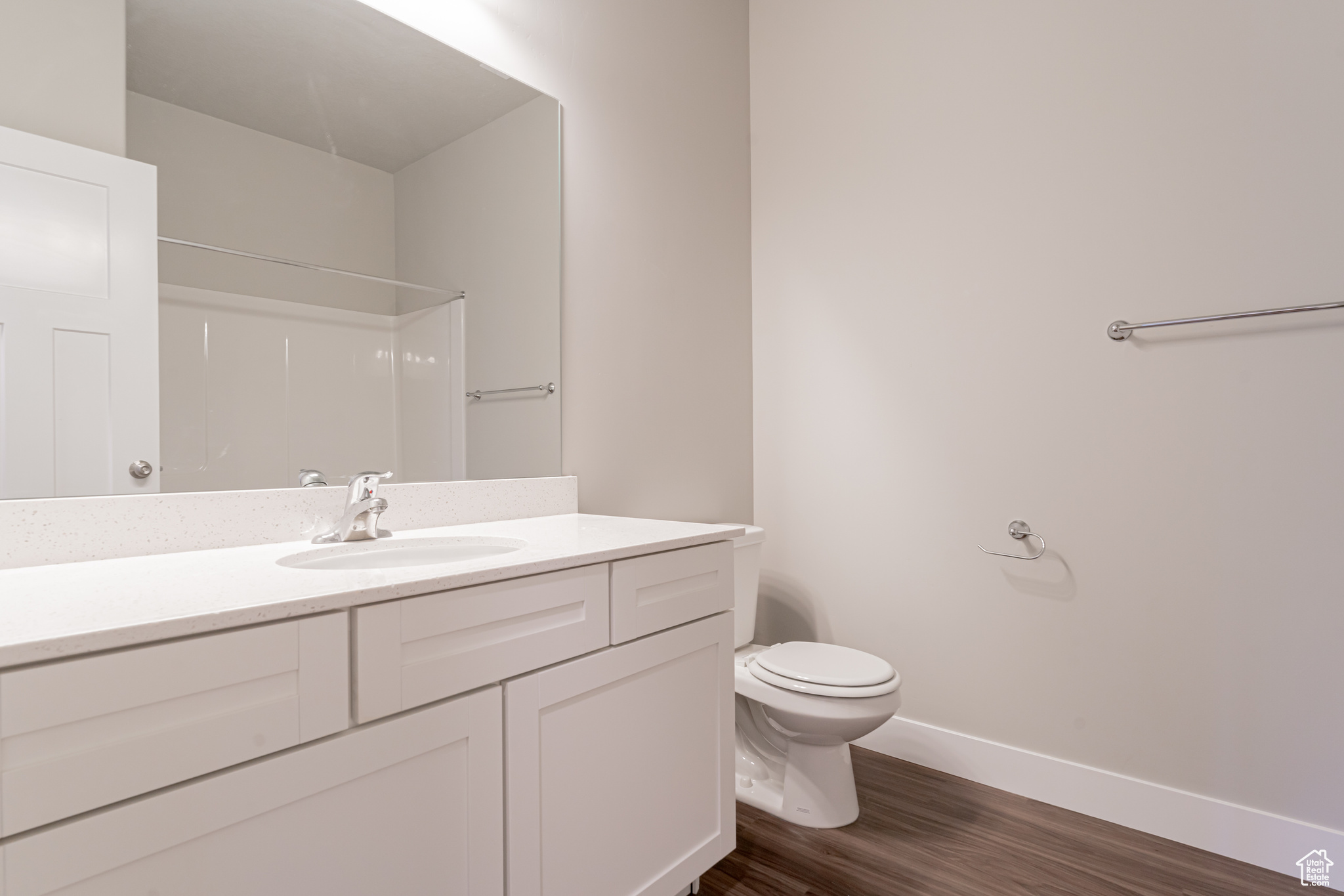 Bathroom with walk in shower, vanity, toilet, and hardwood / wood-style flooring