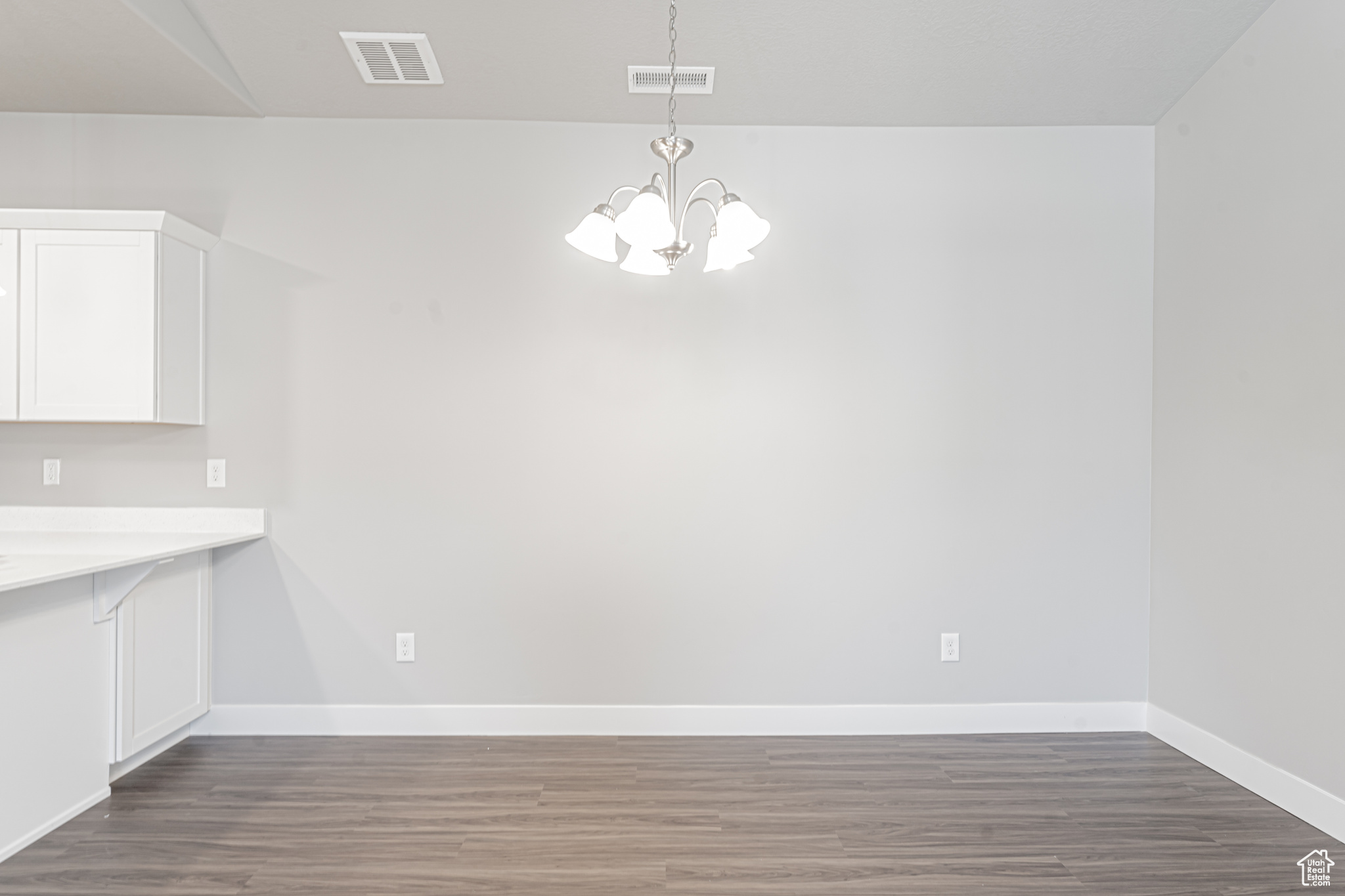 Unfurnished dining area with hardwood / wood-style flooring and a chandelier