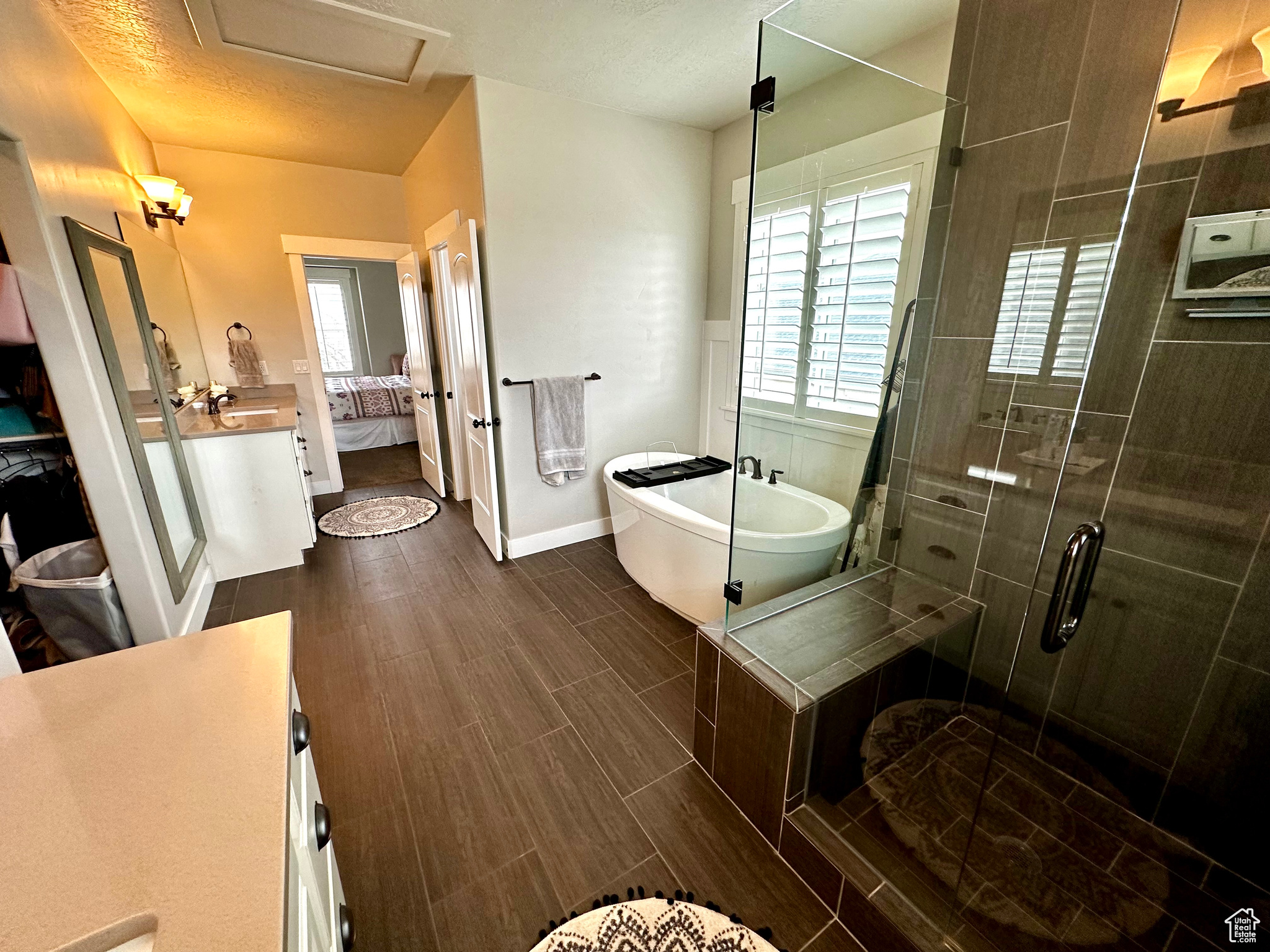 Bathroom with plenty of natural light, large vanity, and shower with separate bathtub