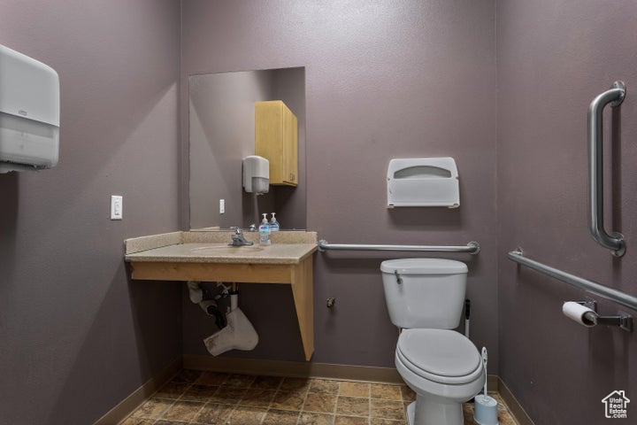 Bathroom featuring sink, tile floors, and toilet