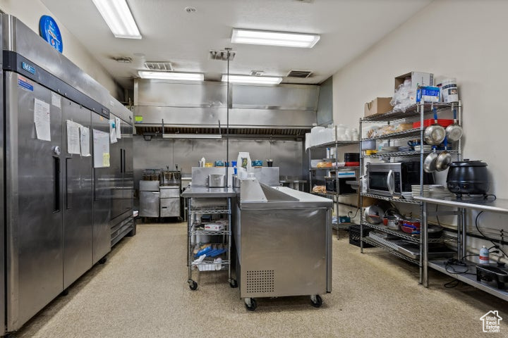 Interior space with appliances with stainless steel finishes, a breakfast bar, and stainless steel counters