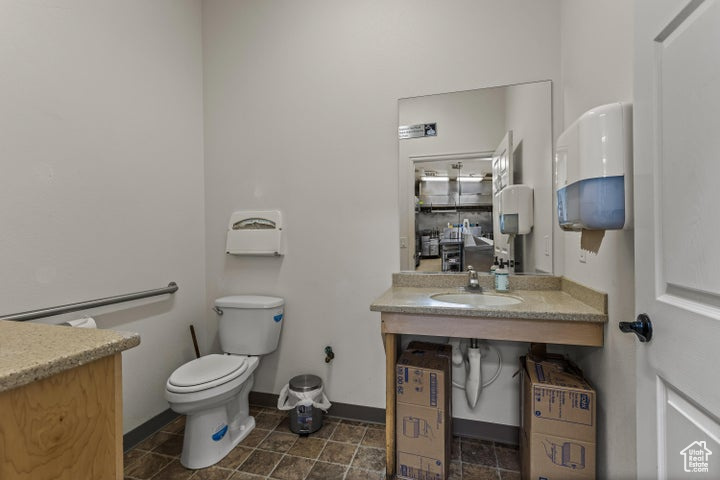 Bathroom featuring vanity, tile flooring, and toilet