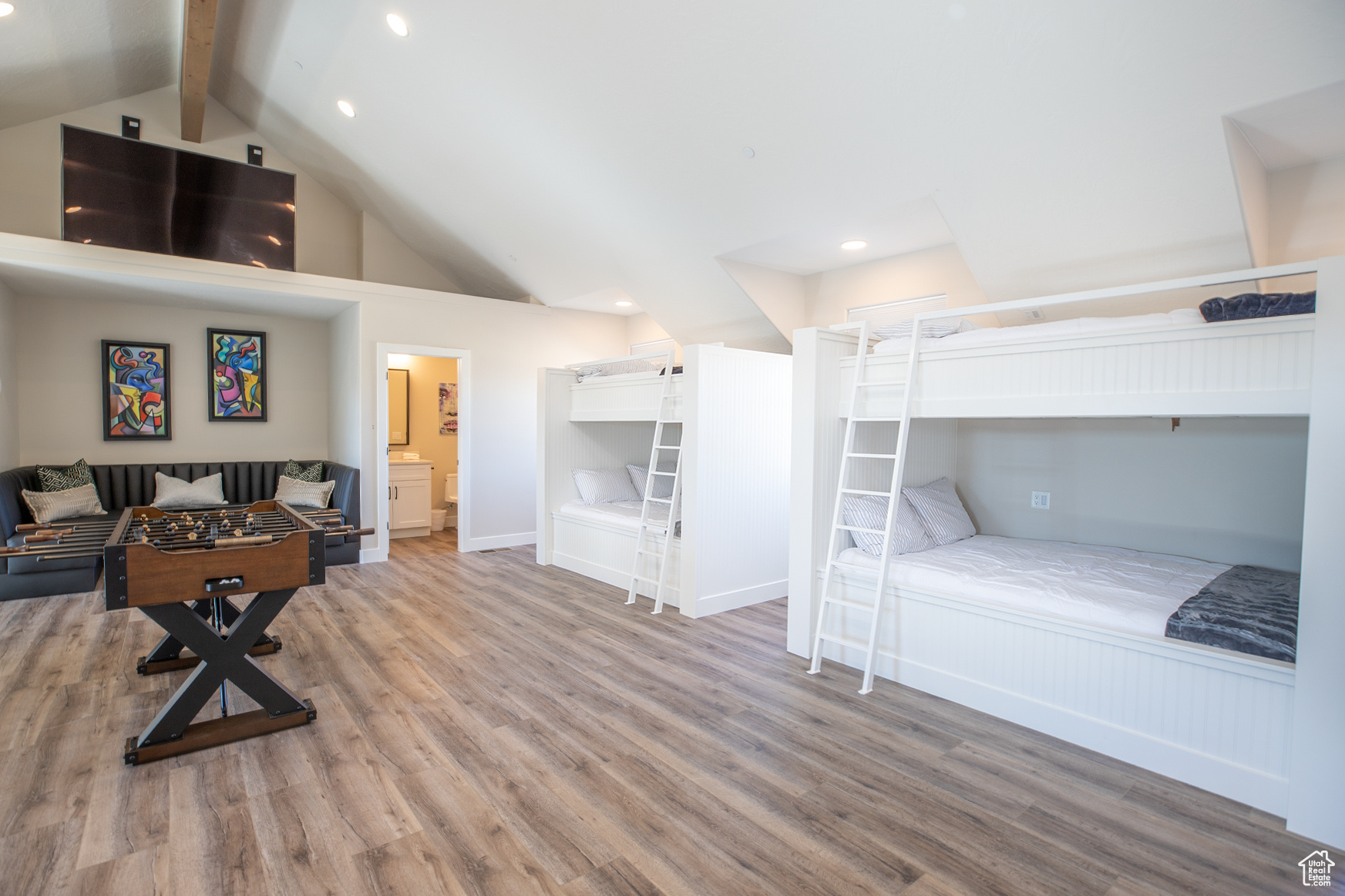Bedroom with beam ceiling, light hardwood / wood-style flooring, connected bathroom, and high vaulted ceiling