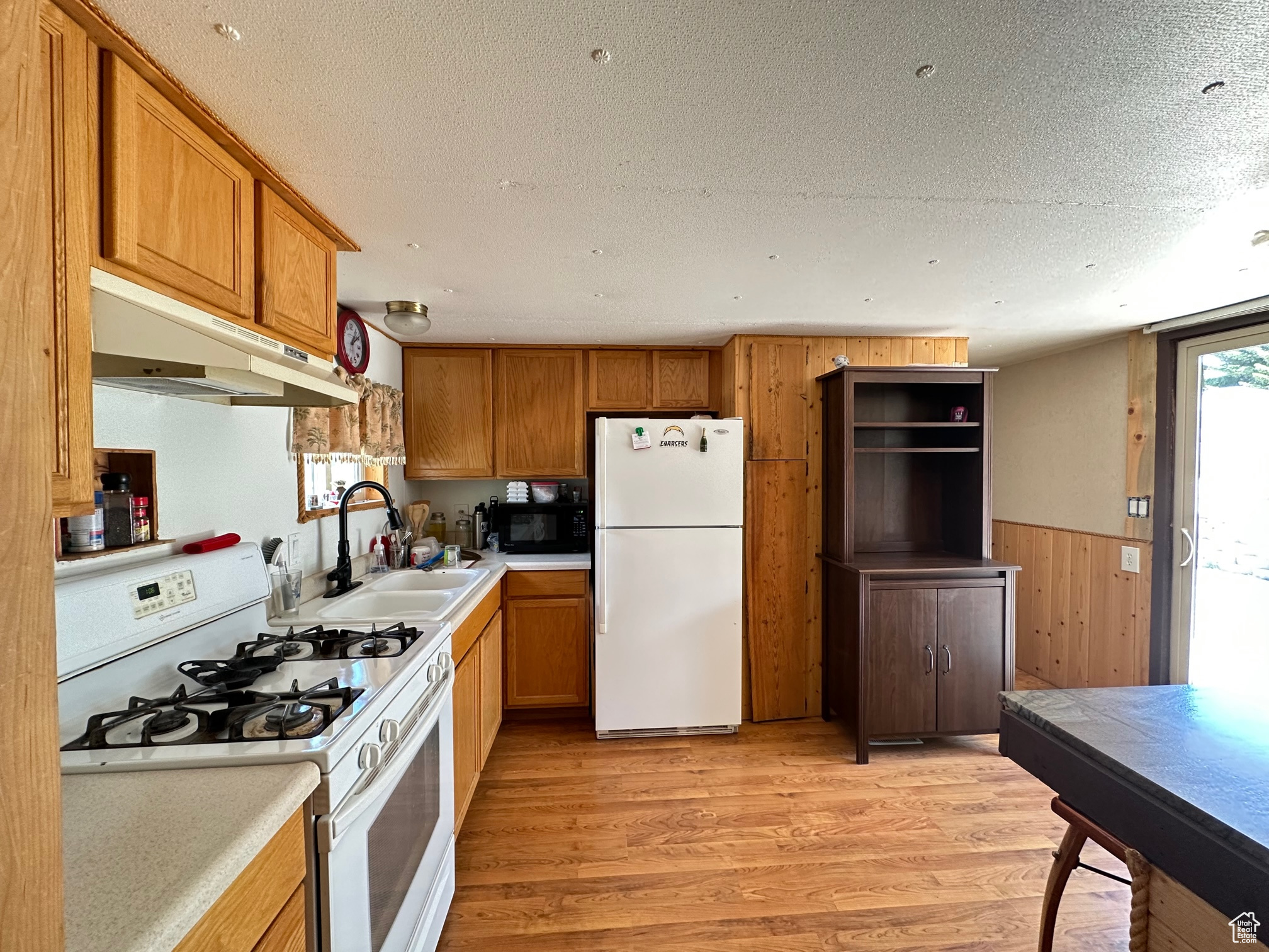 Kitchen with white appliances, laminate floors, sink
