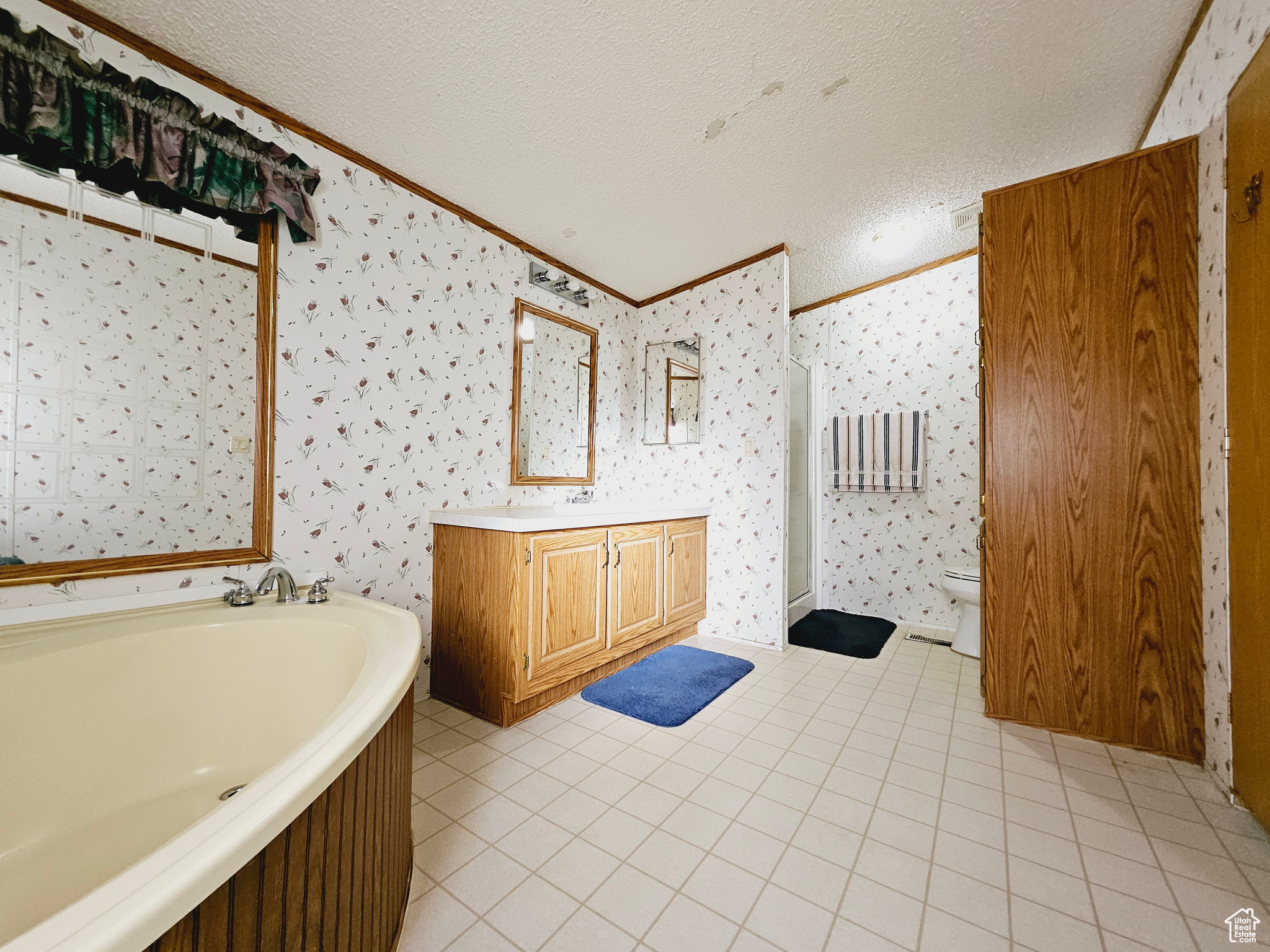 Full bathroom featuring vanity, toilet, a textured ceiling, and tile flooring