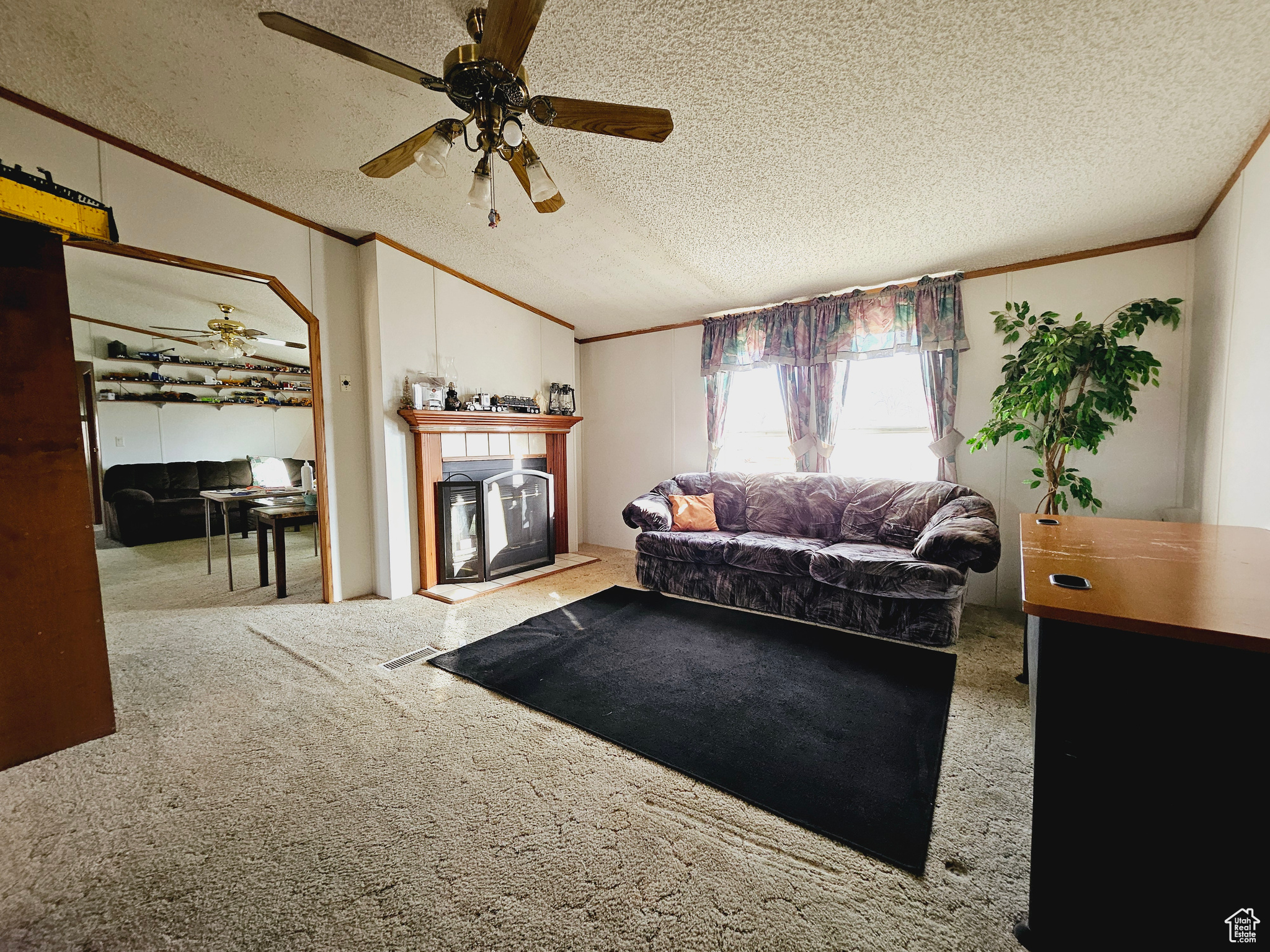 Living room with light carpet, a textured ceiling, and ceiling fan