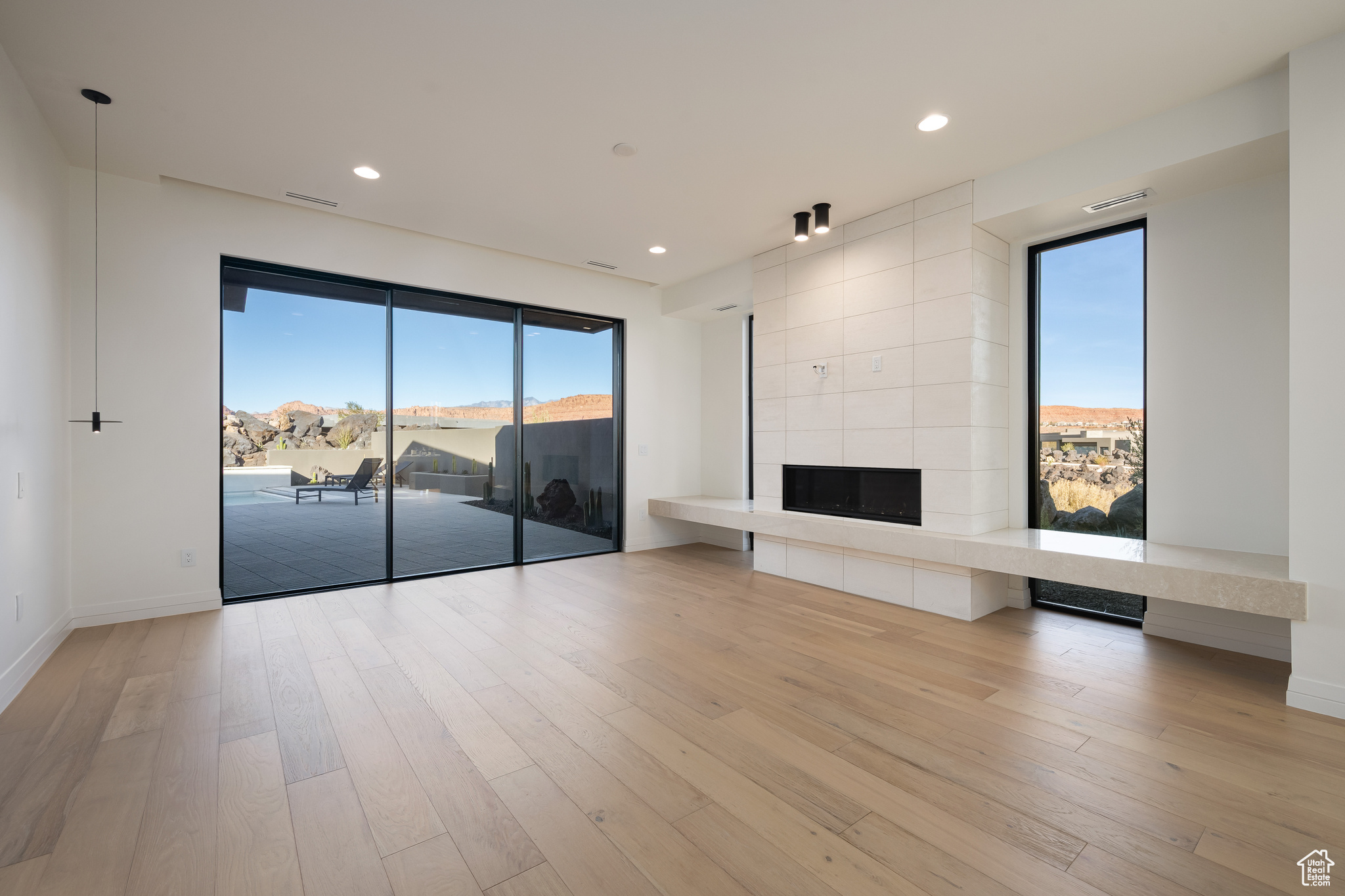 Unfurnished living room featuring light hardwood / wood-style floors and a tiled fireplace