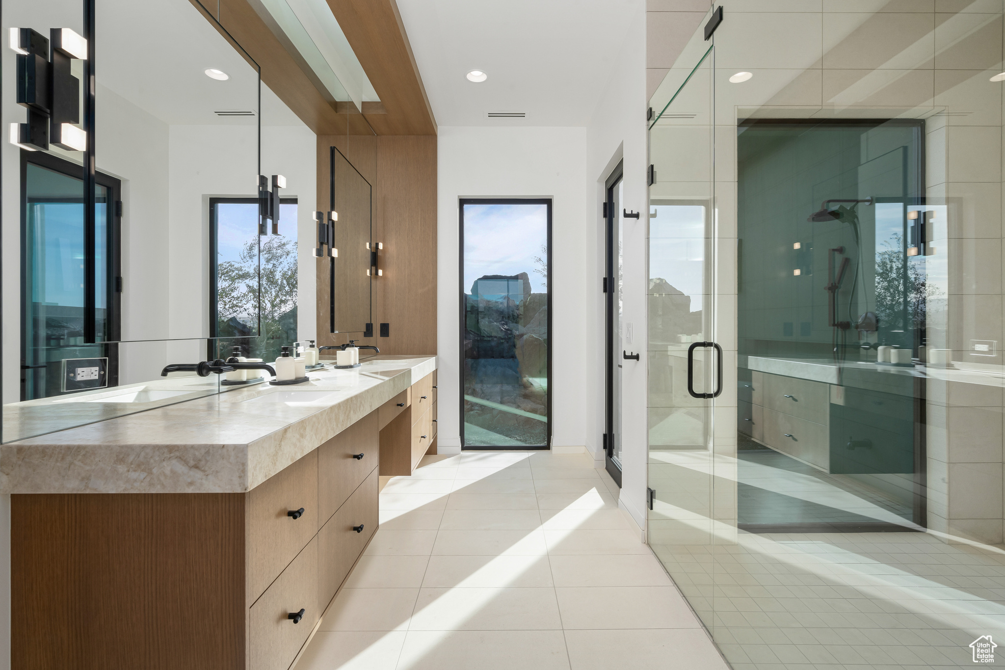 Bathroom with tile patterned flooring, vanity, a healthy amount of sunlight, and an enclosed shower