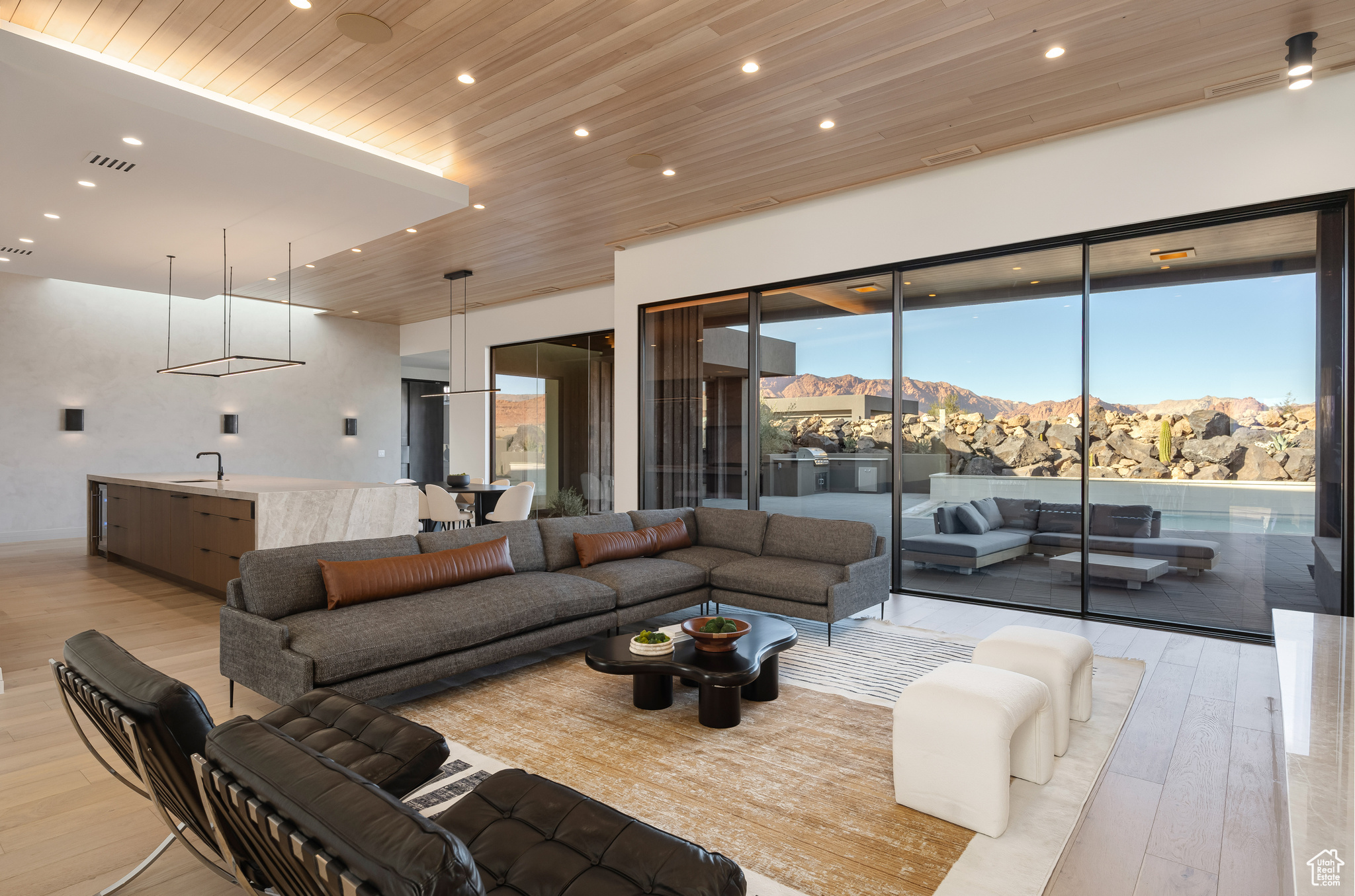 Living room featuring a mountain view, sink, wooden ceiling, and light wood-type flooring