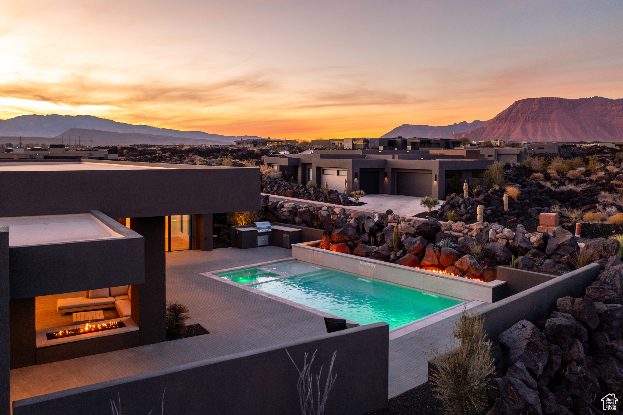 Pool at dusk featuring a mountain view and a patio