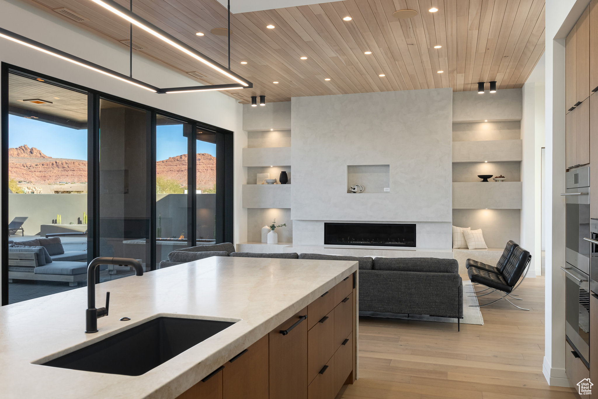 Kitchen with a mountain view, light hardwood / wood-style floors, wooden ceiling, and sink