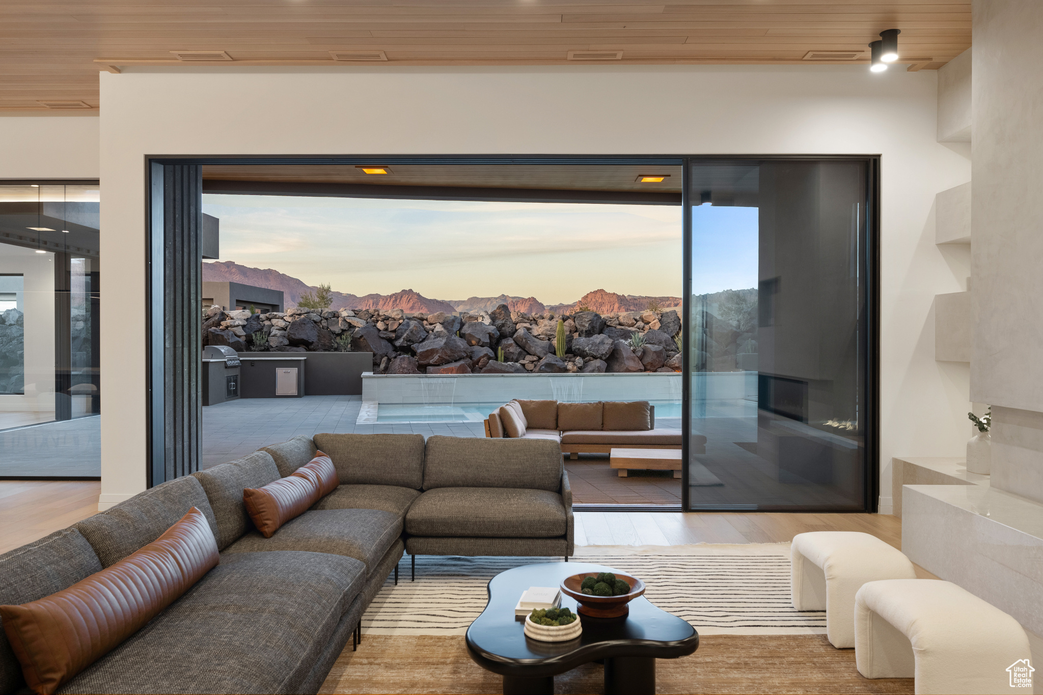 Living room featuring a mountain view, light hardwood / wood-style flooring, plenty of natural light, and wooden ceiling