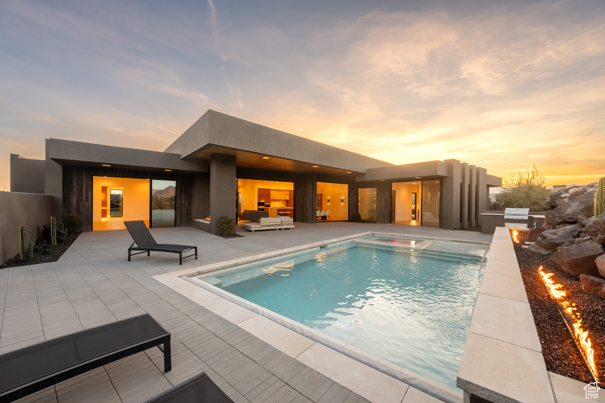 Pool at dusk with grilling area and a patio