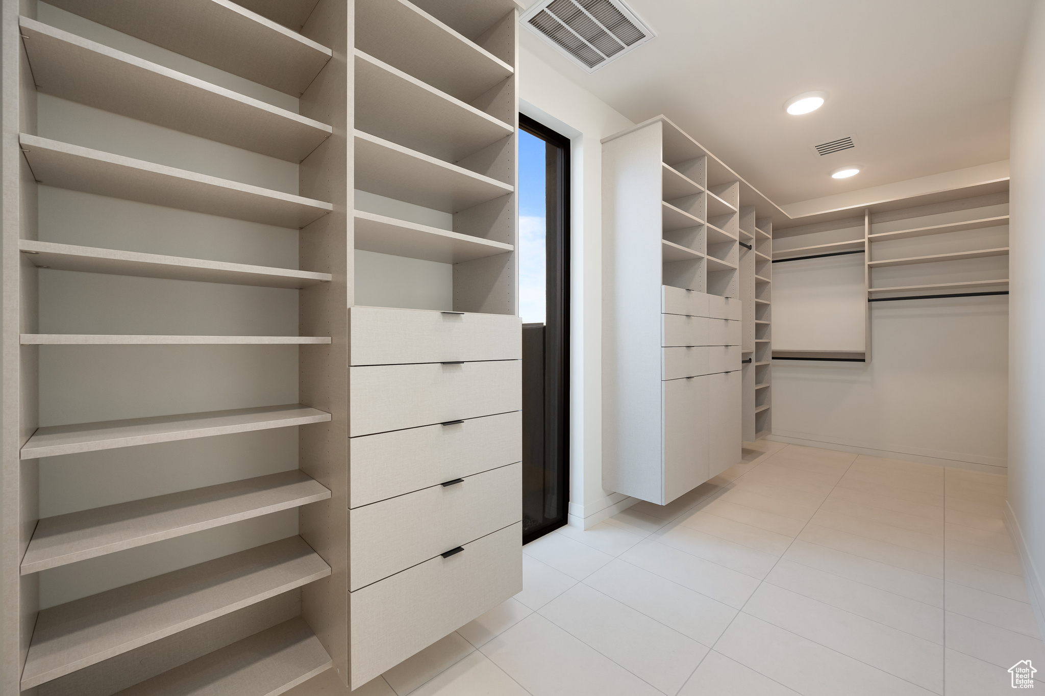 Spacious closet with light tile patterned floors