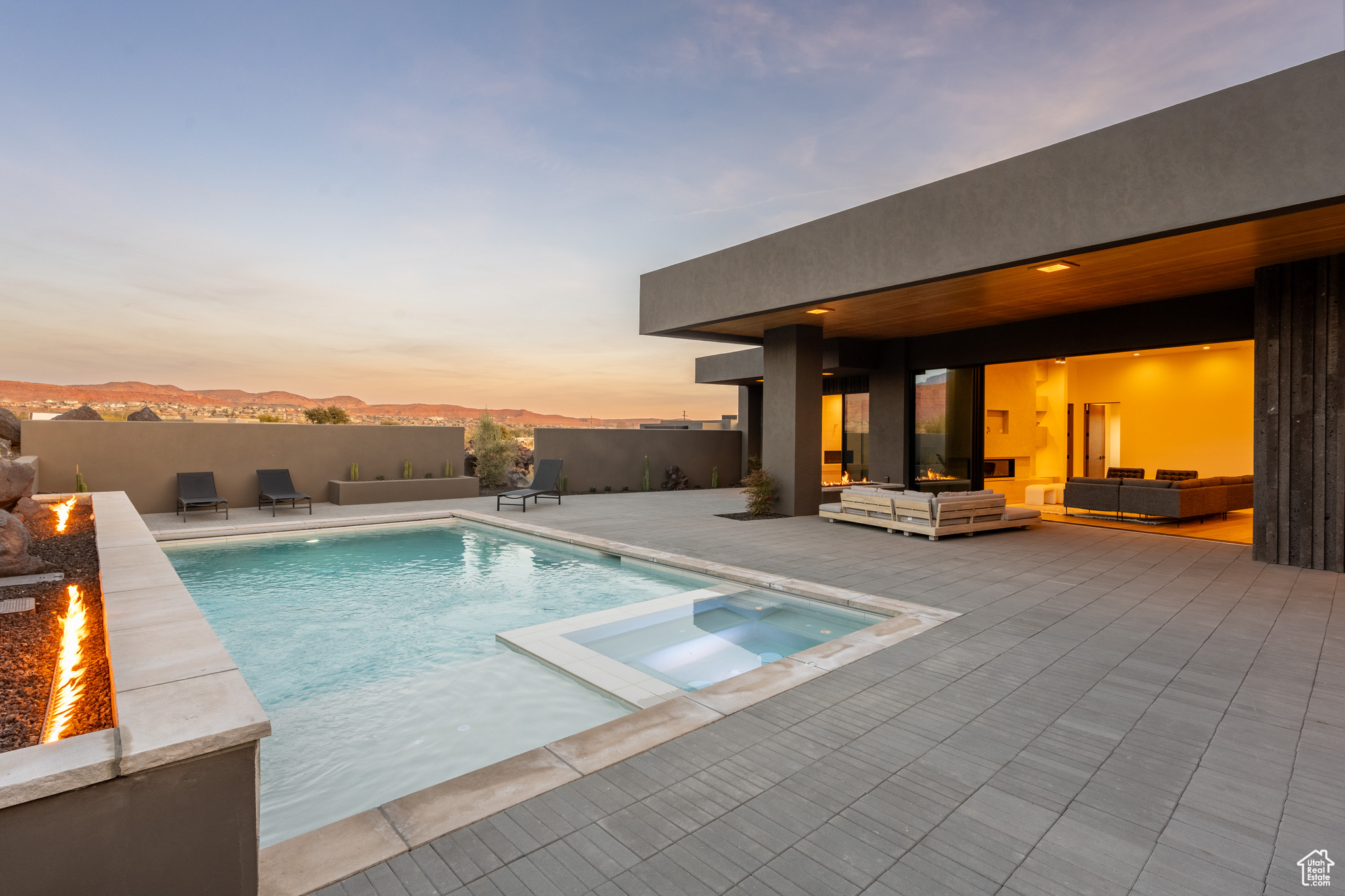 Pool at dusk with a patio area, a mountain view, and an outdoor living space with a fire pit