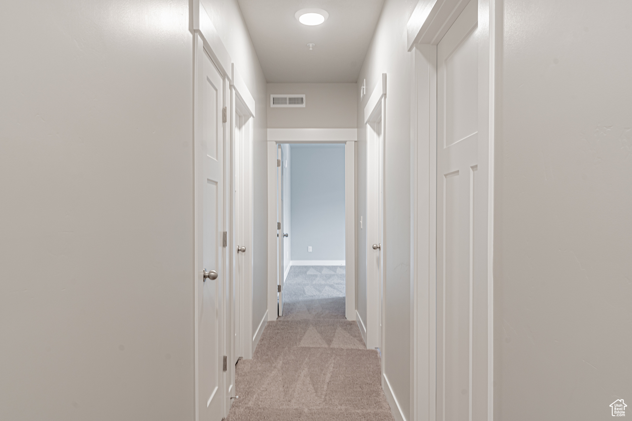 Hallway with light colored carpet