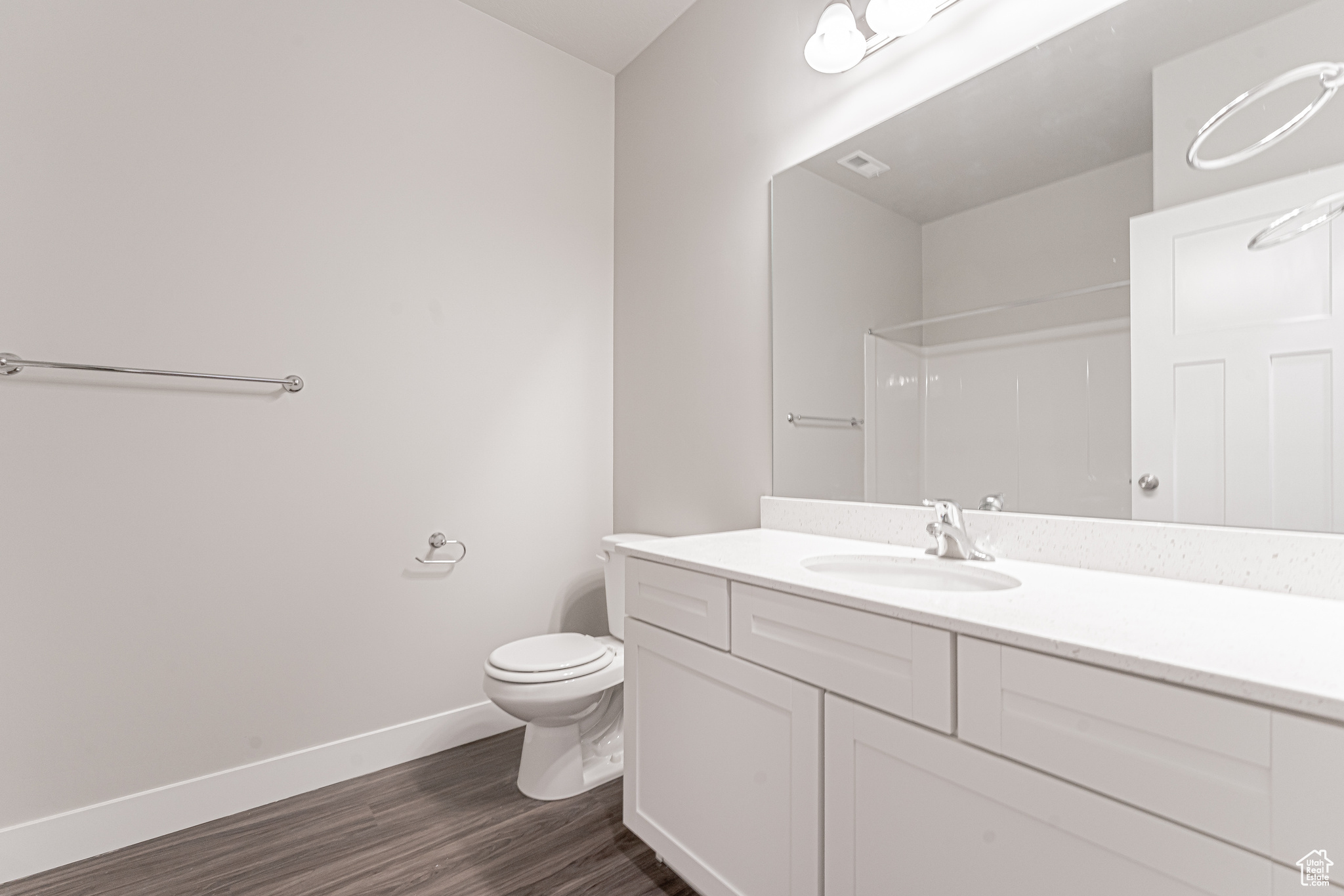 Bathroom featuring vanity, hardwood / wood-style flooring, and toilet