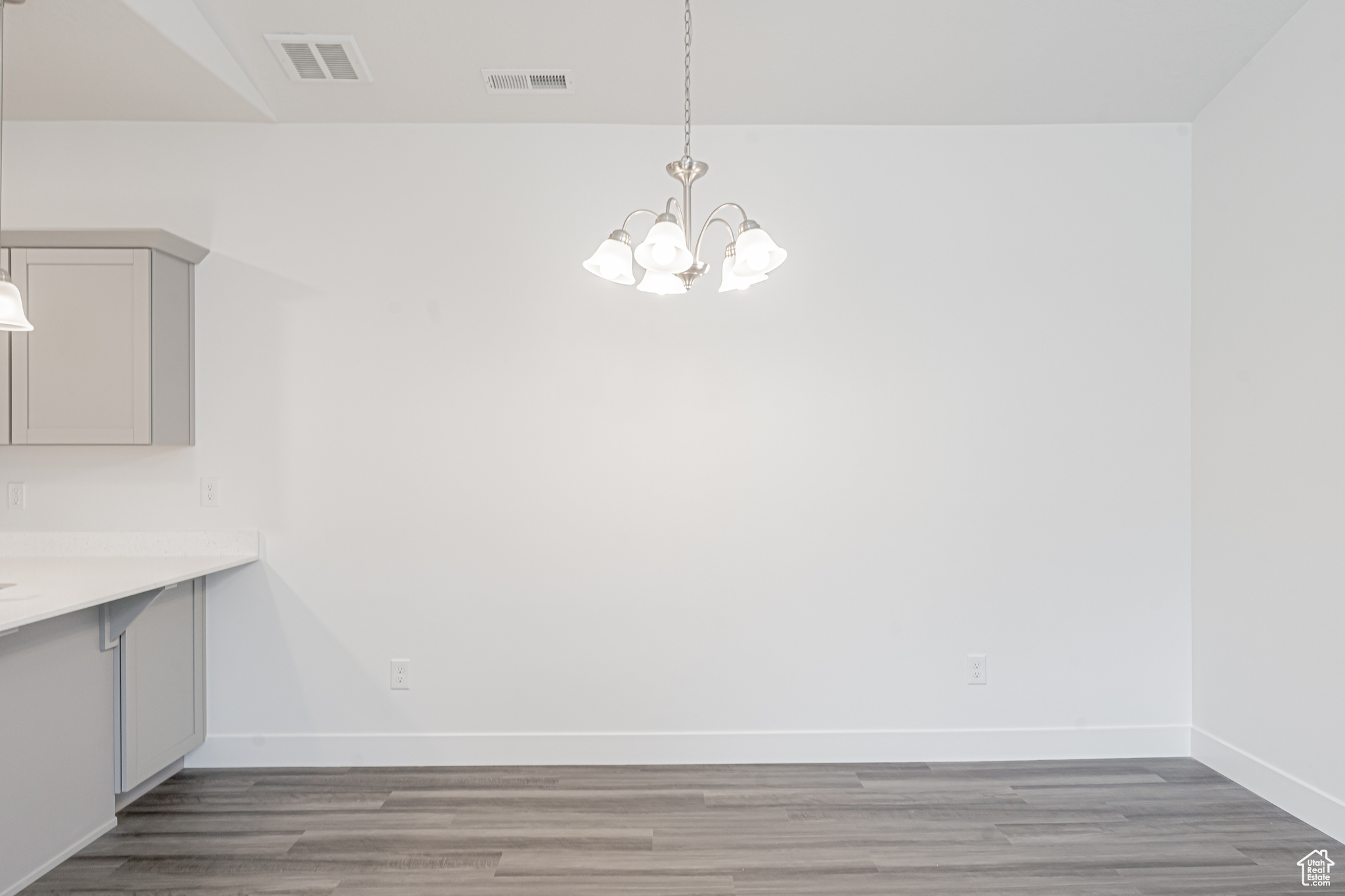 Unfurnished dining area featuring hardwood / wood-style flooring and an inviting chandelier