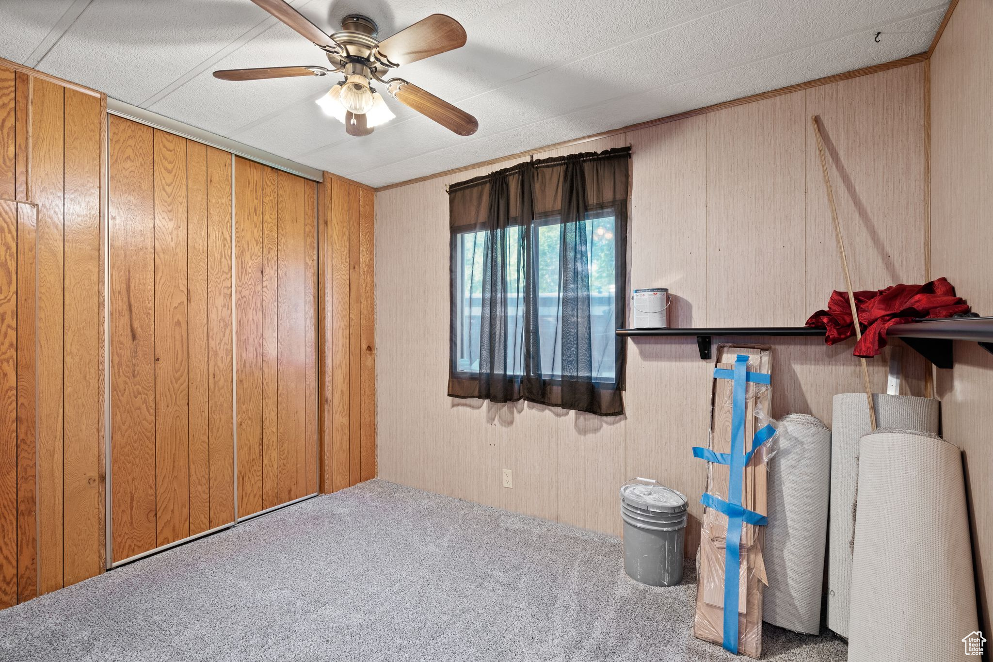 Miscellaneous room featuring carpet floors, ceiling fan, and wood walls