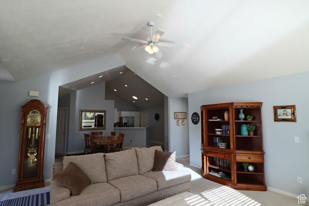 Living room with light carpet, lofted ceiling, and ceiling fan