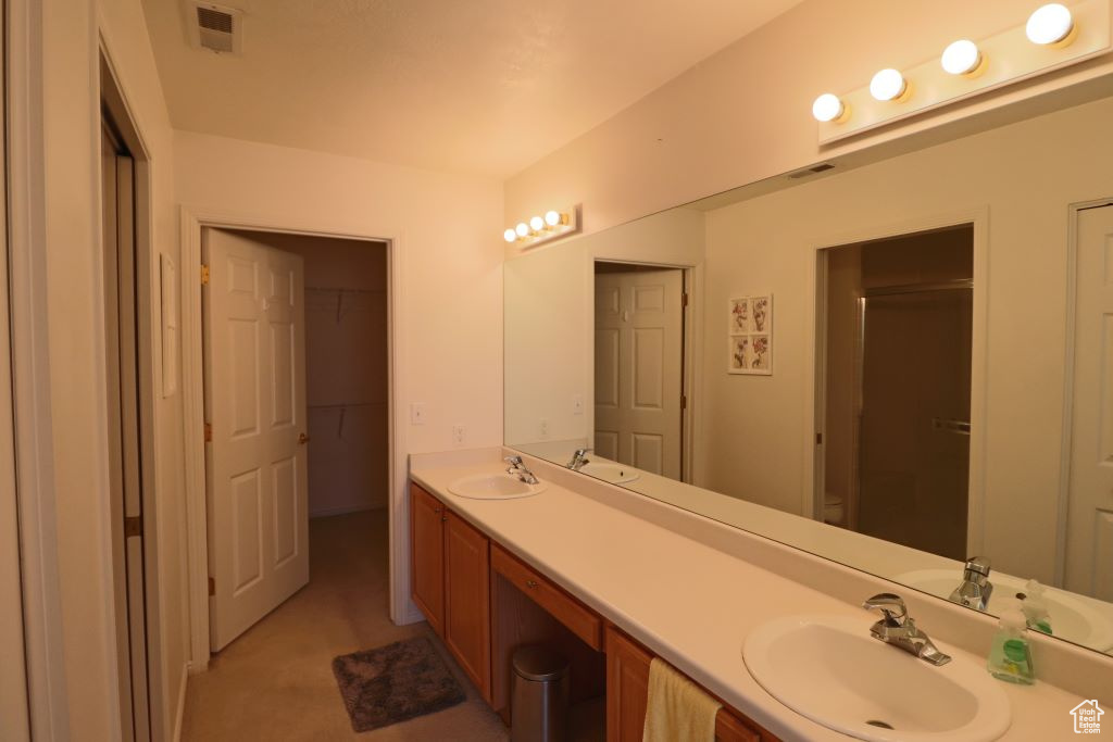 Bathroom with toilet and dual bowl vanity