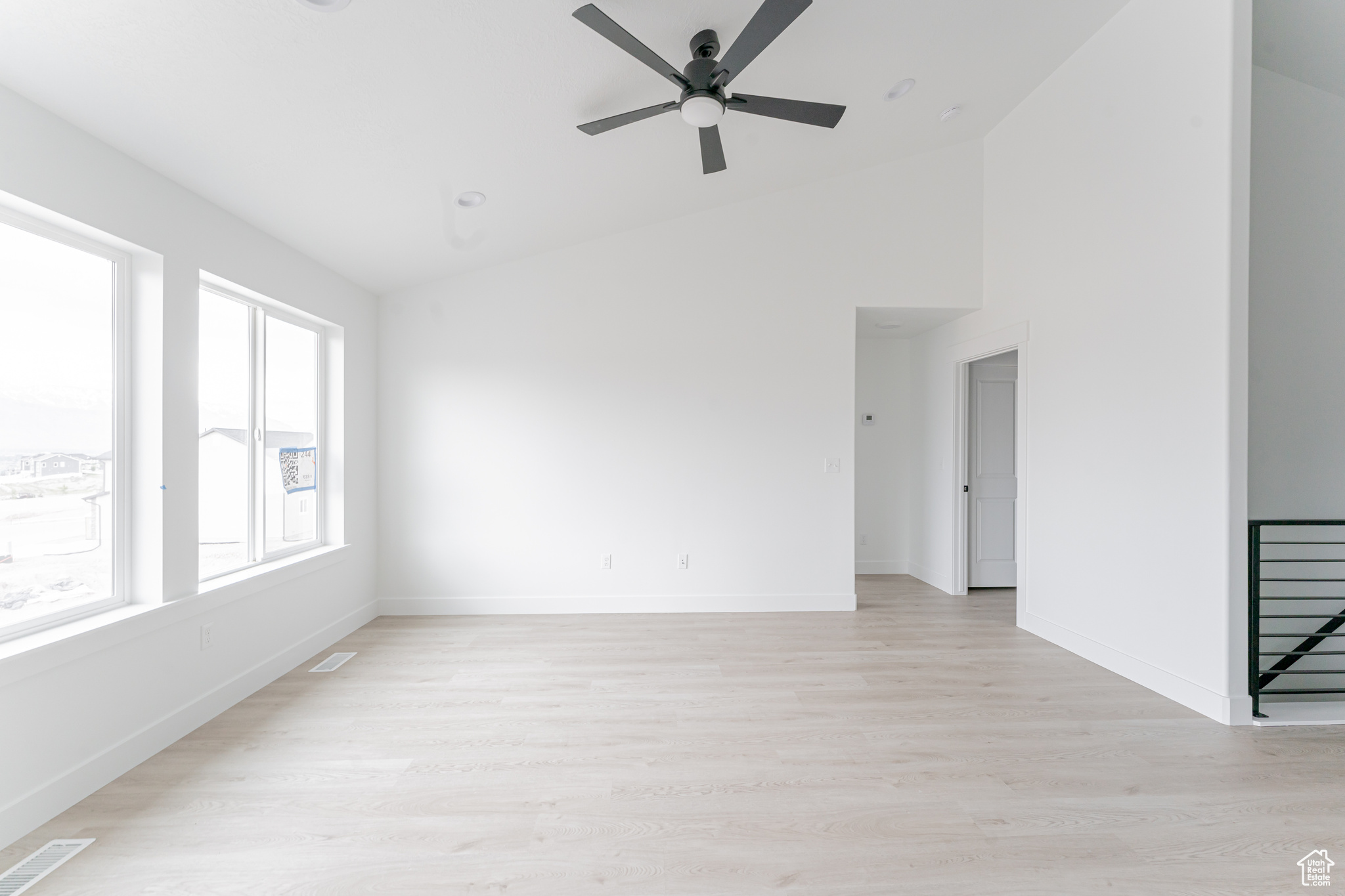 Spare room with ceiling fan, light hardwood / wood-style floors, and lofted ceiling