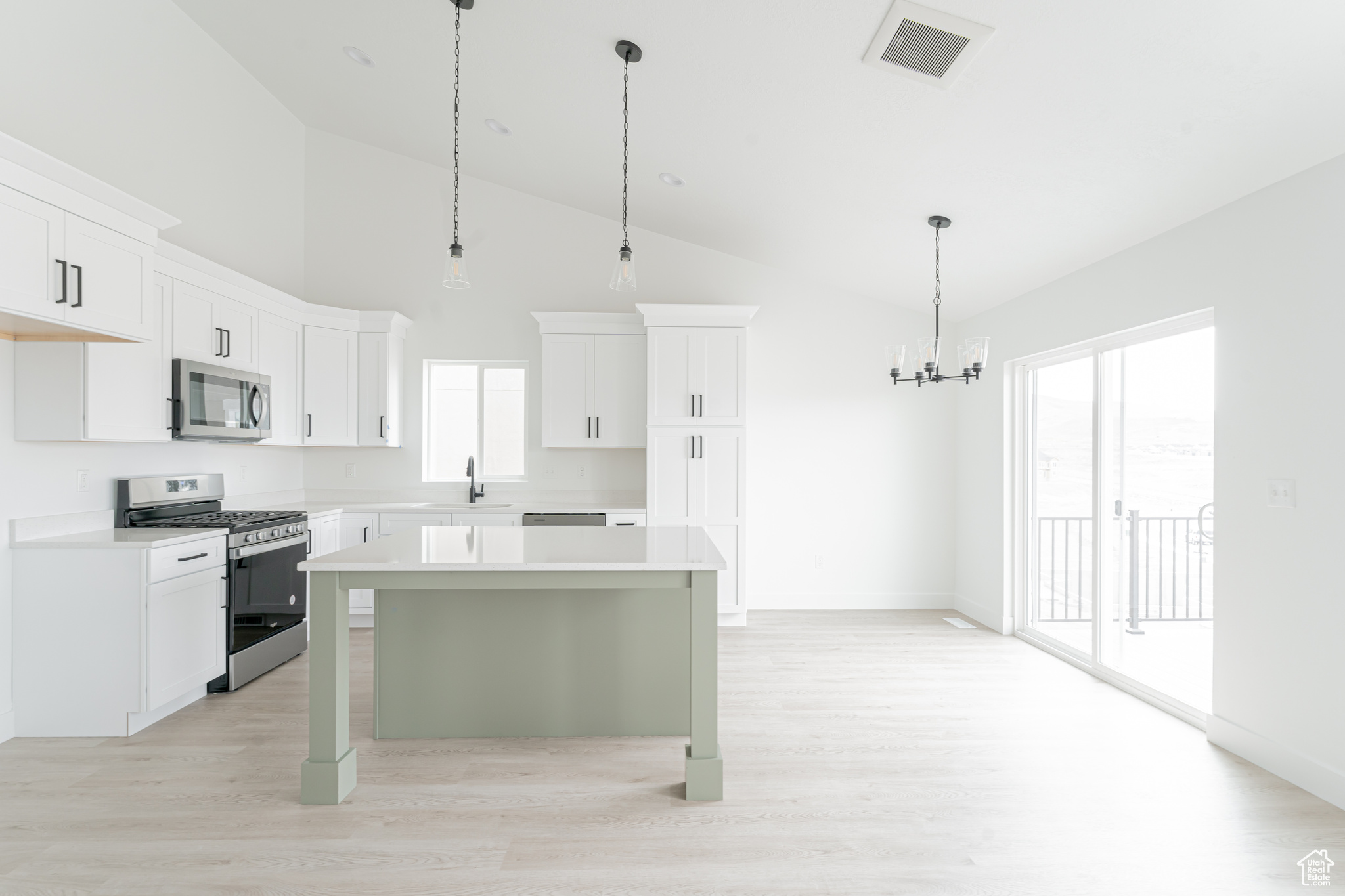 Kitchen with plenty of natural light, light hardwood / wood-style flooring, a center island, and appliances with stainless steel finishes