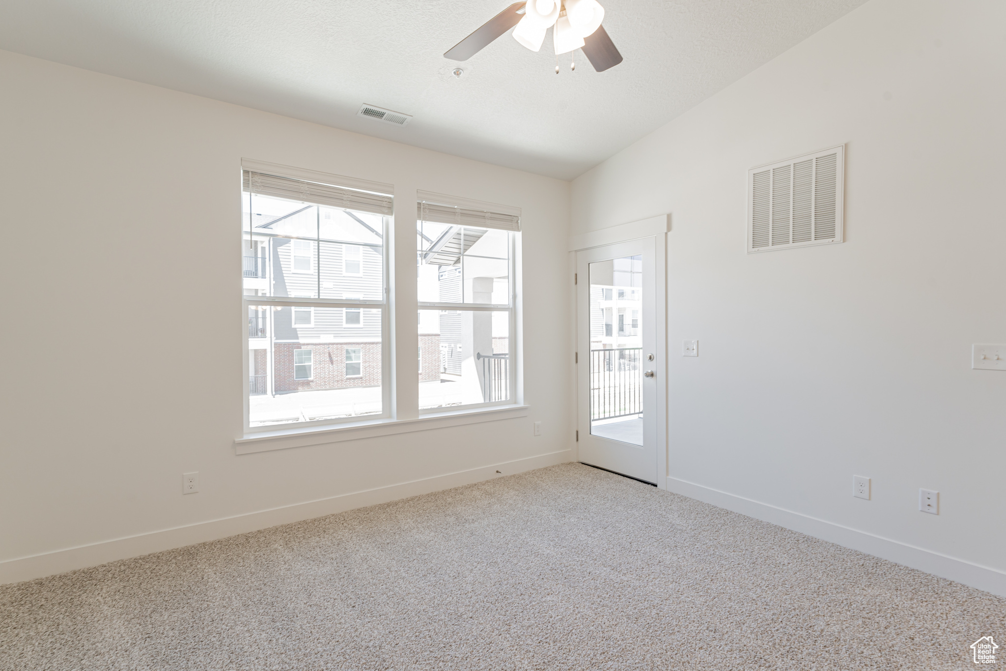 Spare room featuring carpet and ceiling fan