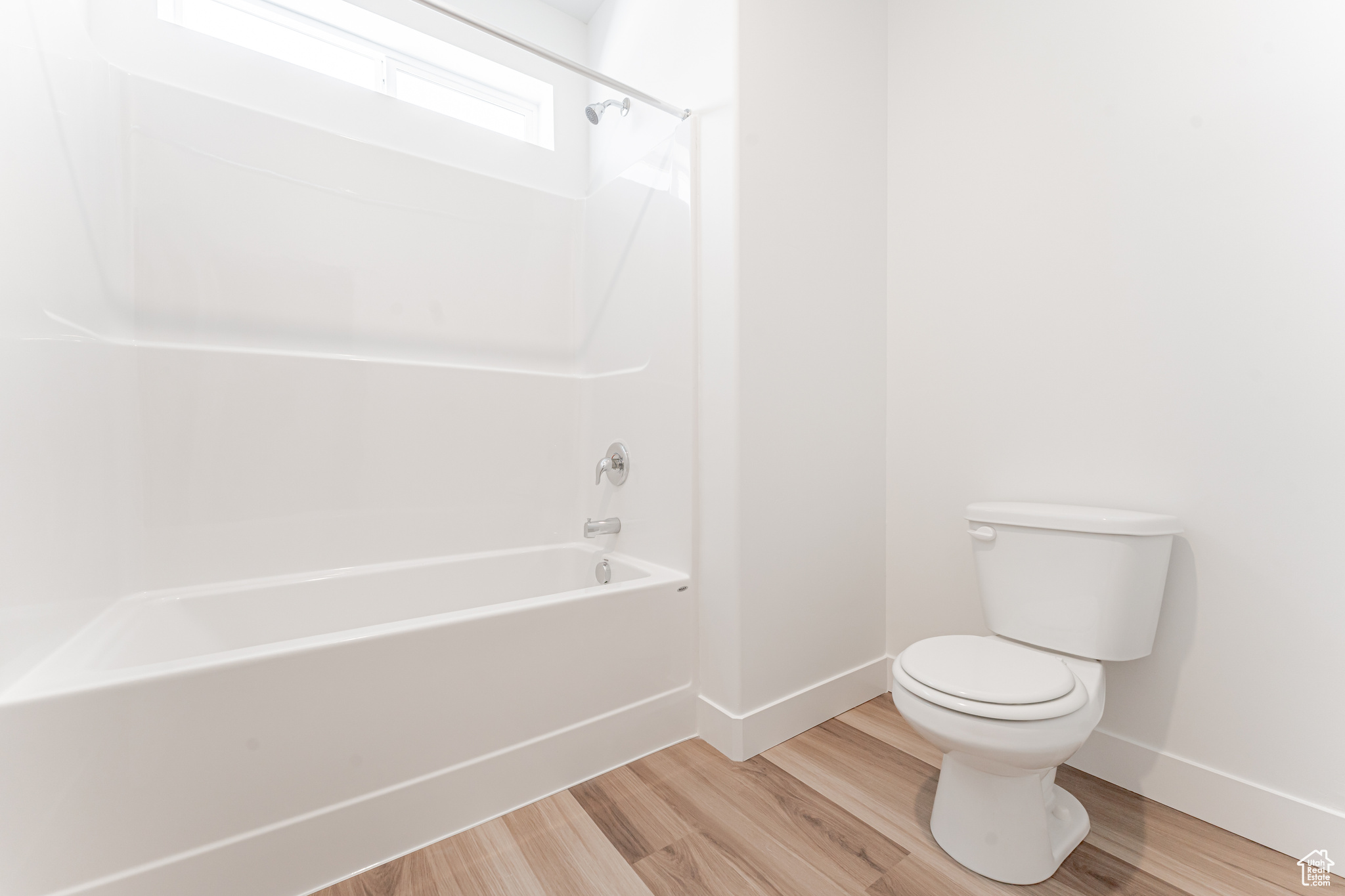 Bathroom featuring hardwood / wood-style flooring, toilet, and shower / tub combination