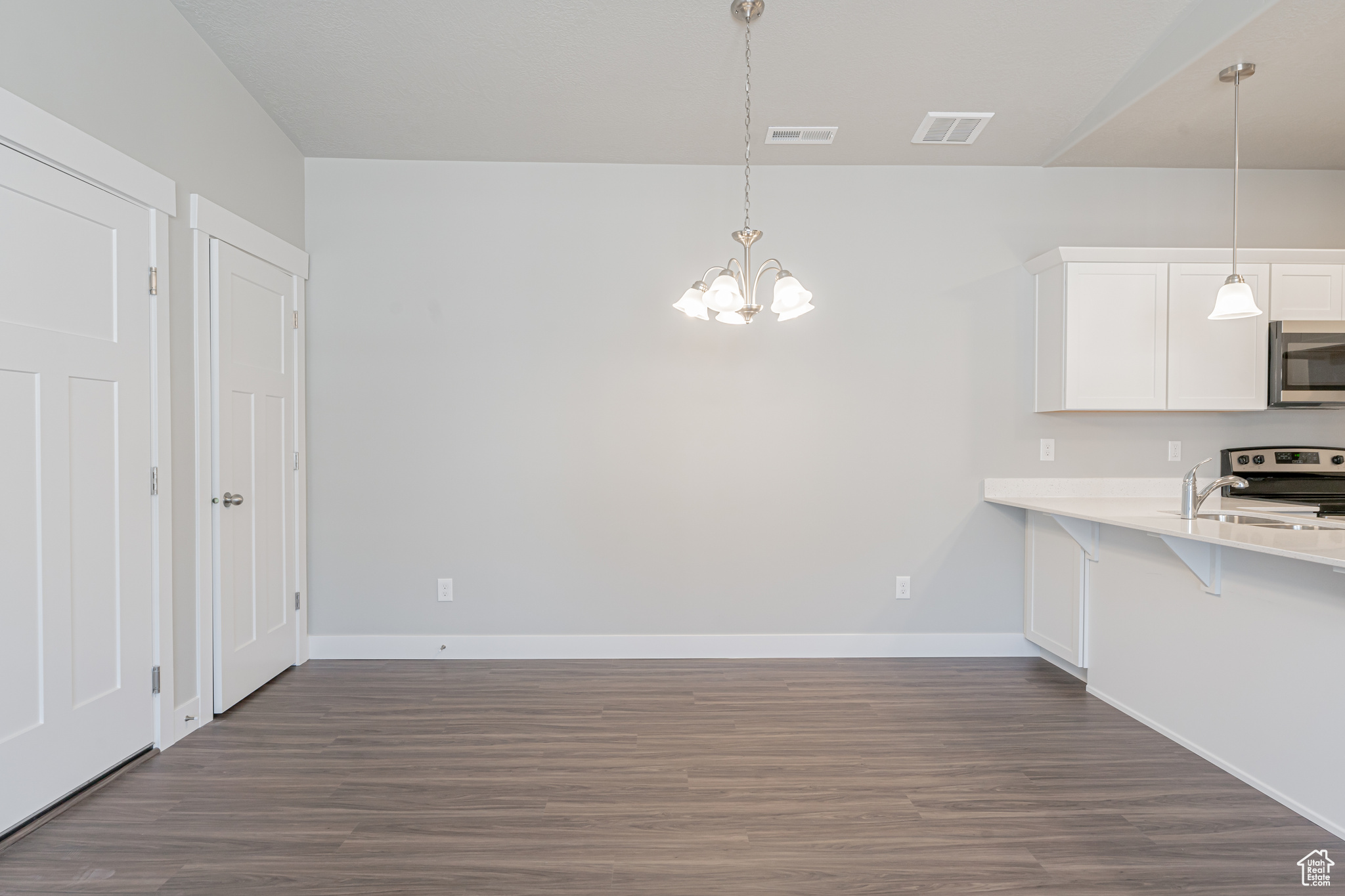 Kitchen featuring range, sink, dark hardwood / wood-style flooring, and hanging light fixtures