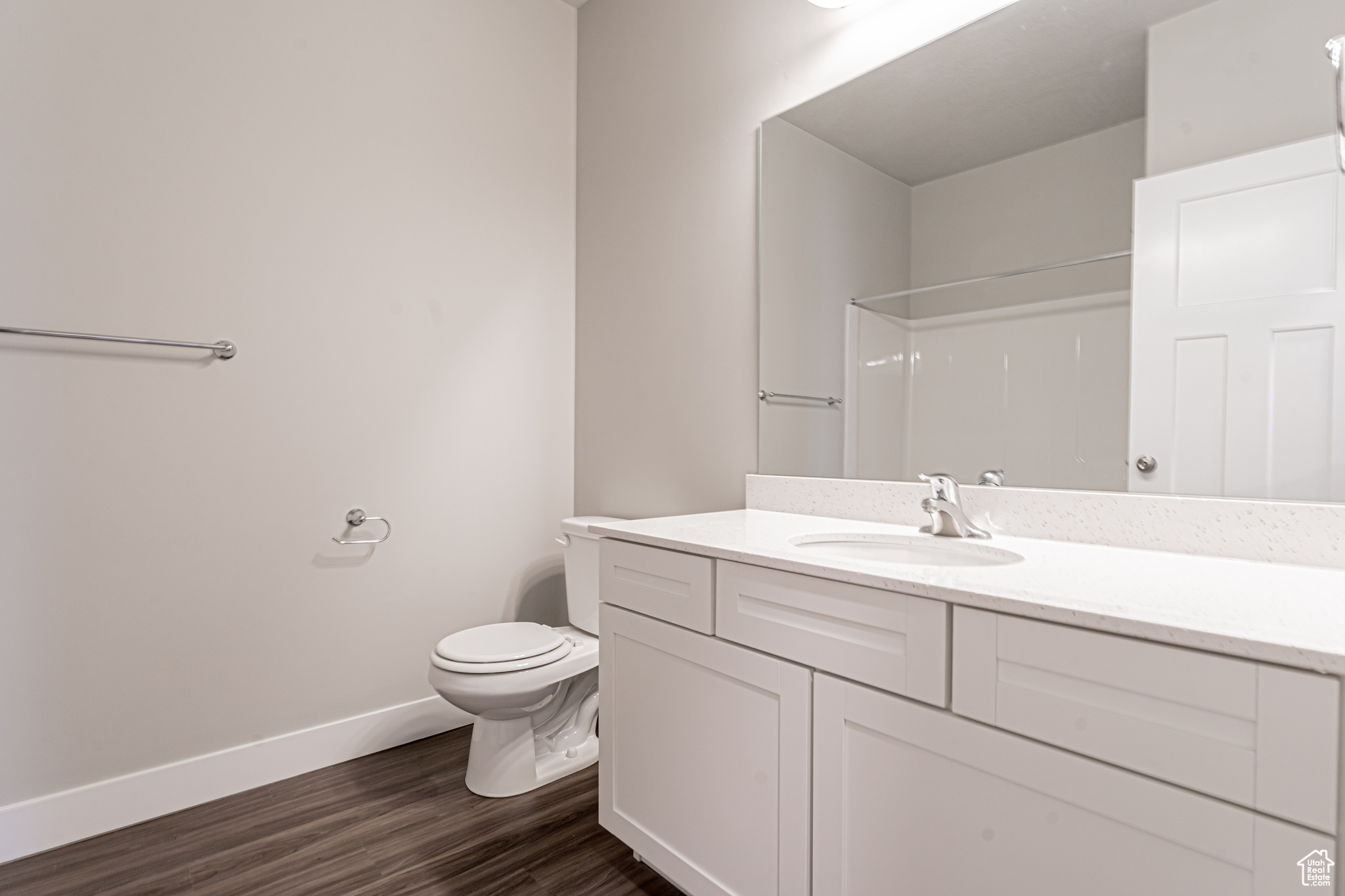 Bathroom with wood-type flooring, toilet, and vanity