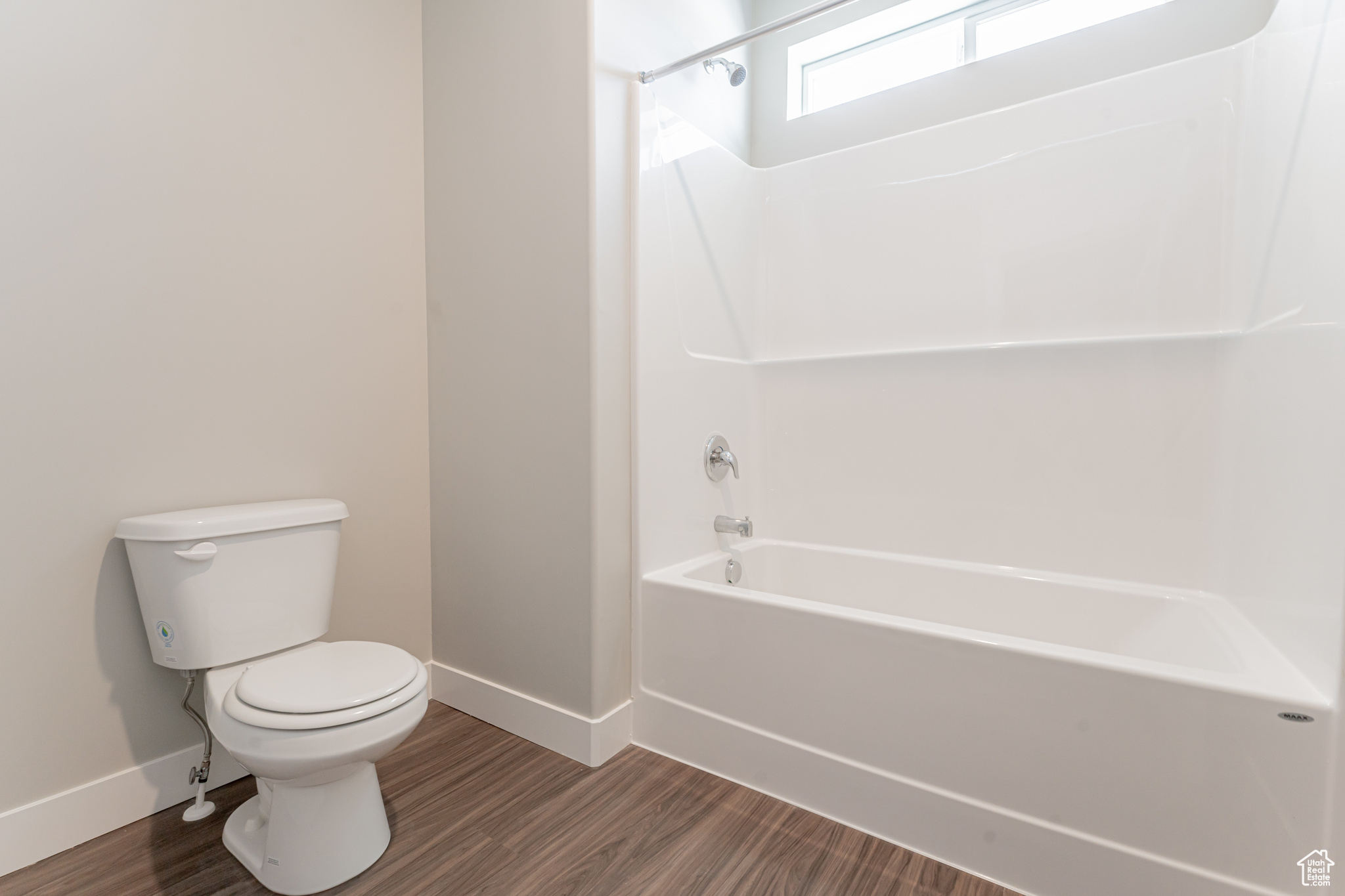 Bathroom with toilet, wood-type flooring, and bathtub / shower combination