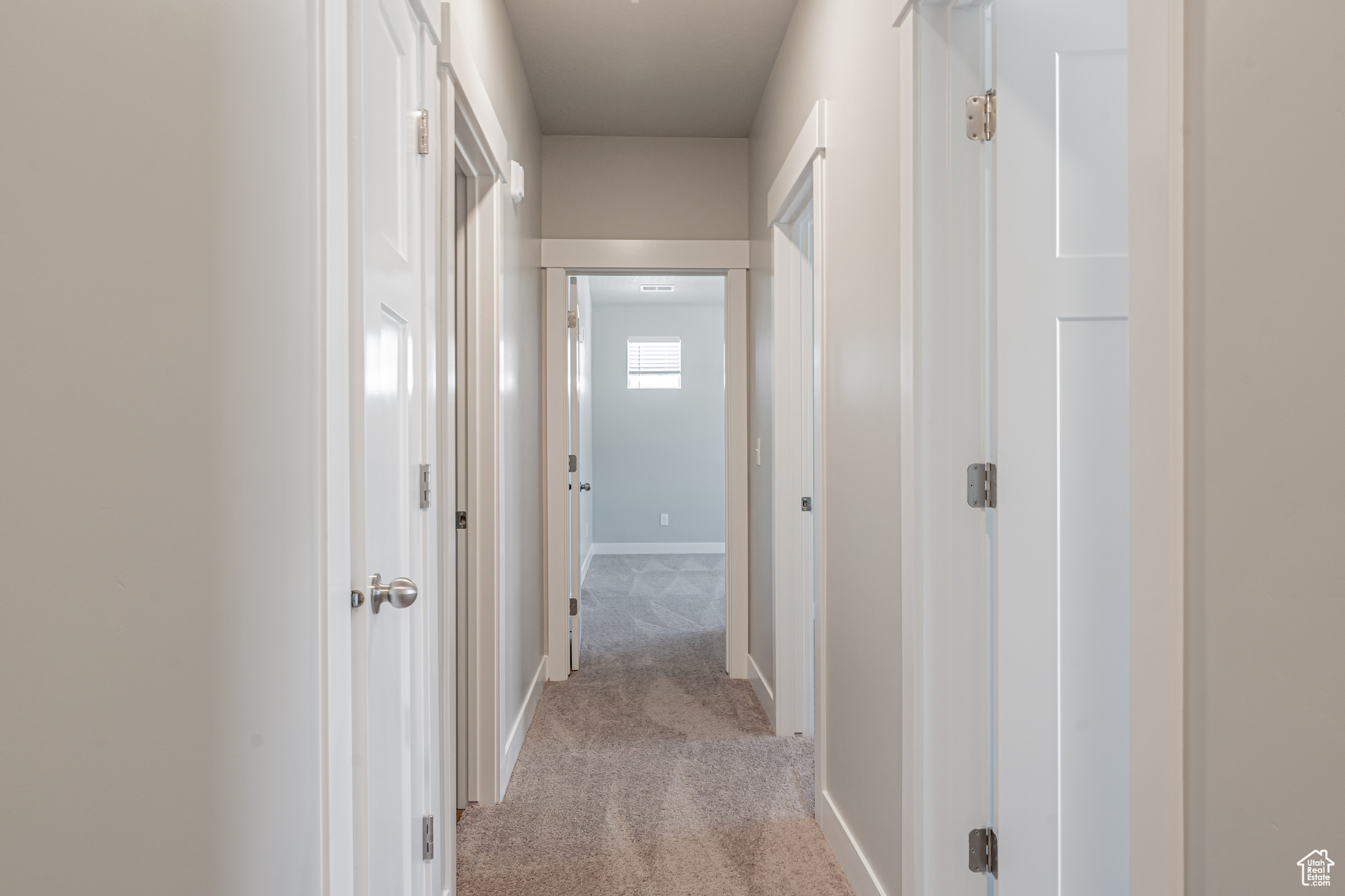 Corridor featuring light carpet