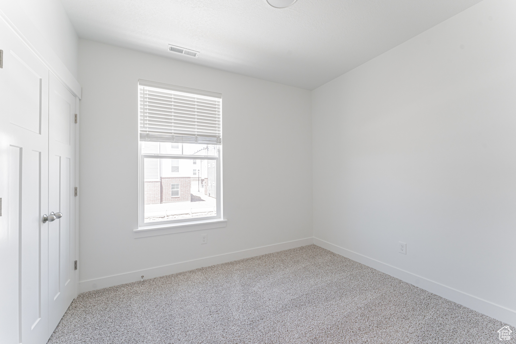 Unfurnished room featuring light carpet