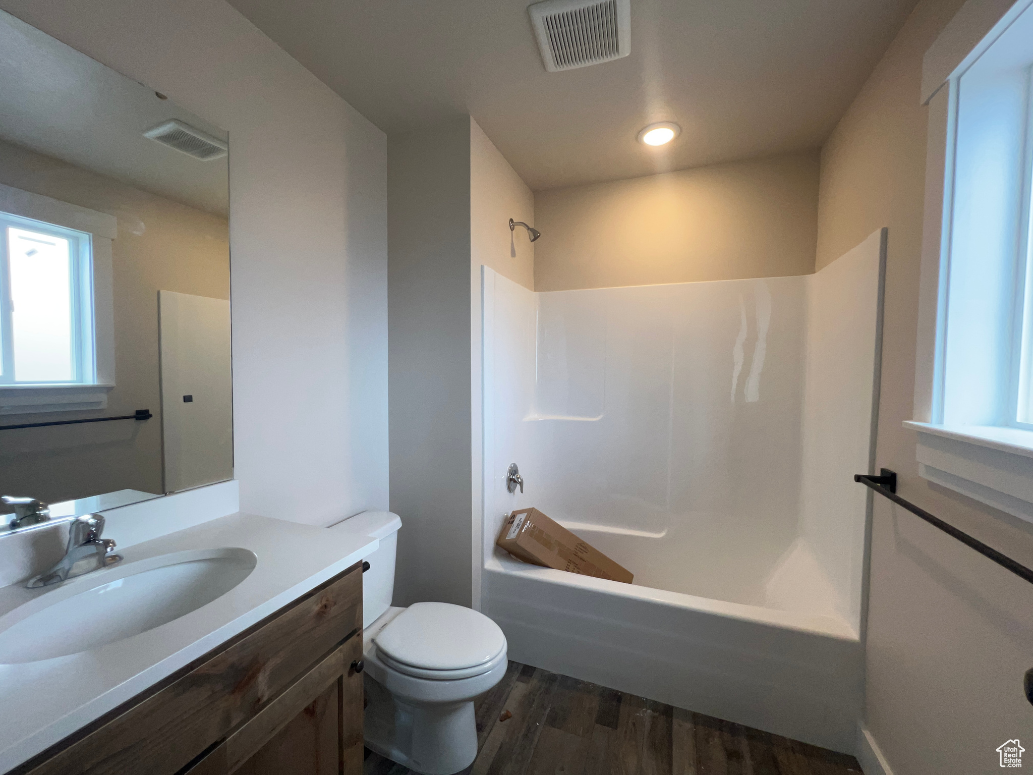 Full bathroom with hardwood / wood-style floors, vanity, toilet, and shower / bathtub combination