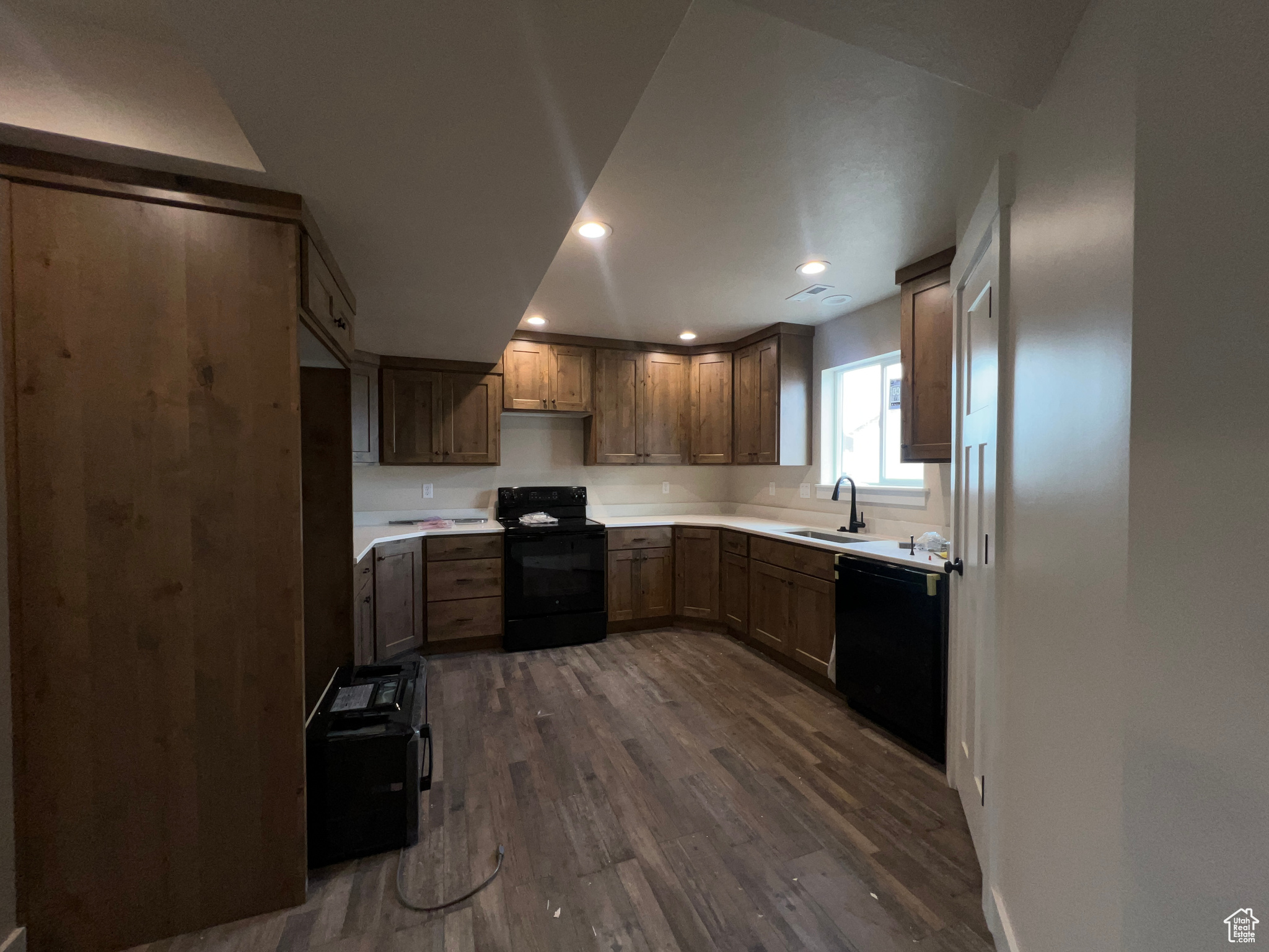 Kitchen featuring black appliances, sink, and dark hardwood / wood-style flooring