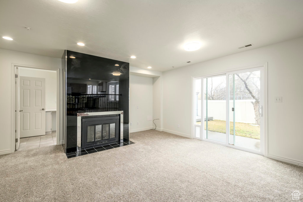 Family room featuring light carpet, fireplace, sliding doors that walk out onto deck and backyard area.