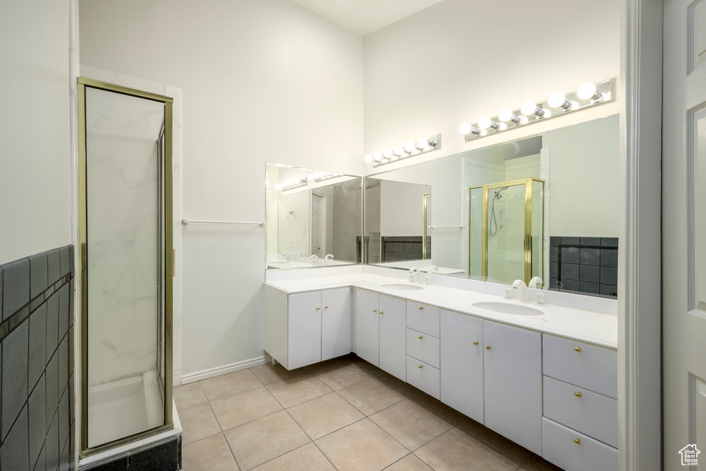 Primary bathroom with natural light, tile floors, oversized vanity, and mirror