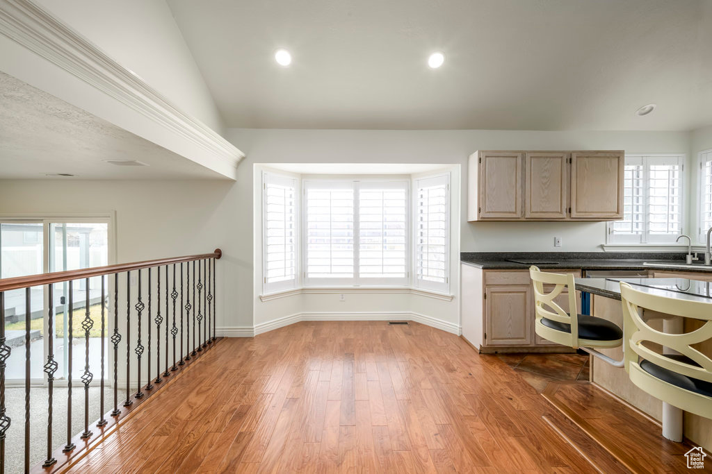 Dining space featuring warm wood flooring, a ceiling fan and bay window with white shutters.