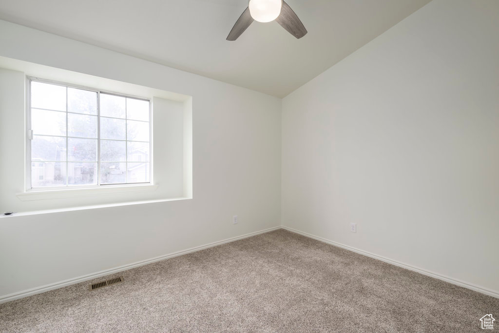 An additional Bedroom or office  with bright windows, ceiling fan, and new carpet.