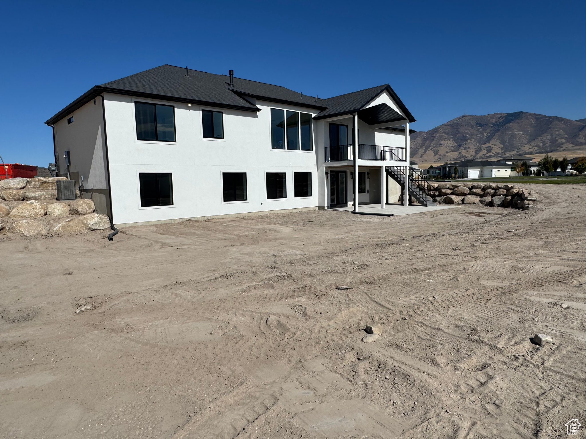 Rear view of property with a mountain view, a balcony, and central air condition unit