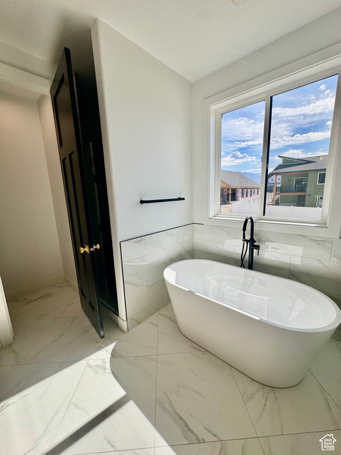 Bathroom featuring tile walls and a washtub