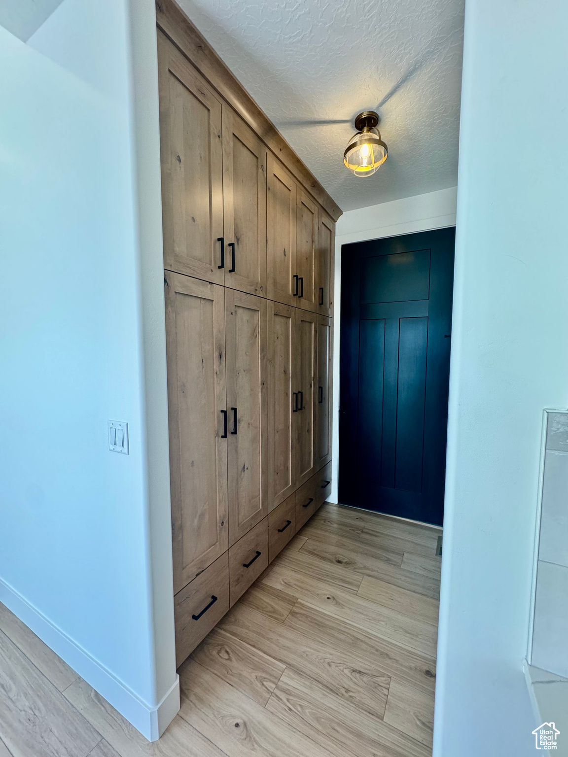 Mudroom with a textured ceiling and light wood-type flooring