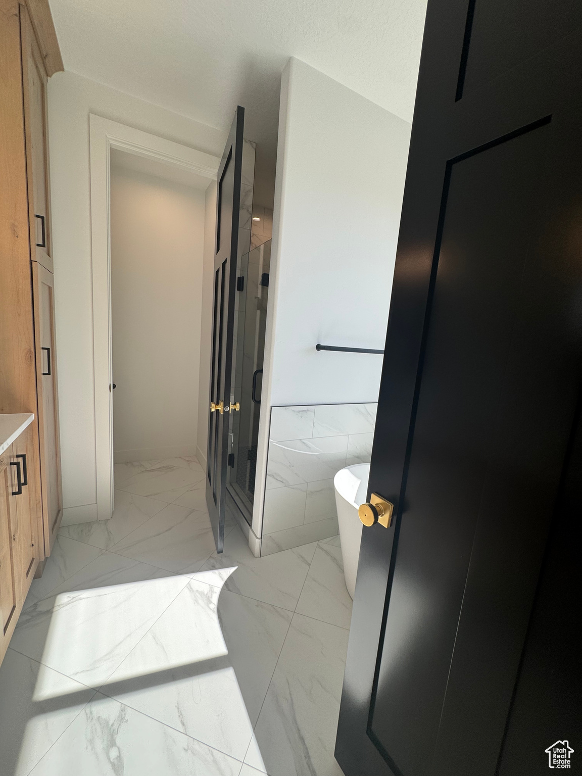 Bathroom with tile walls, vanity, and a tub