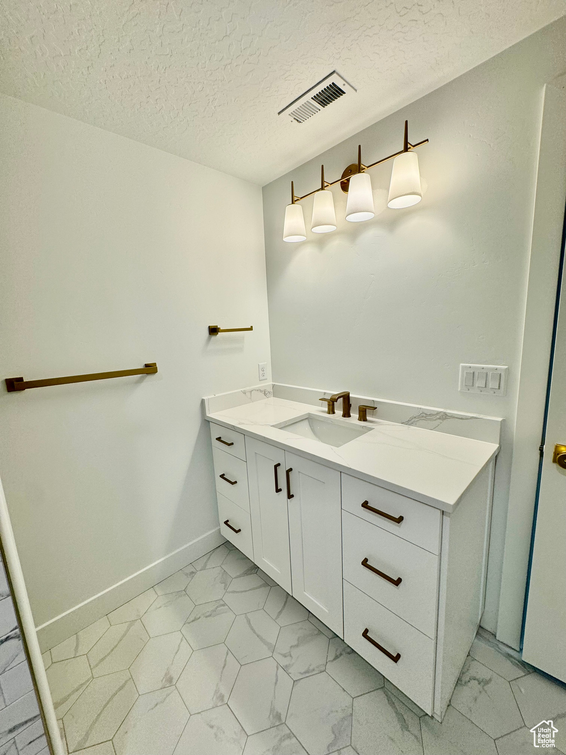 Bathroom with vanity and a textured ceiling