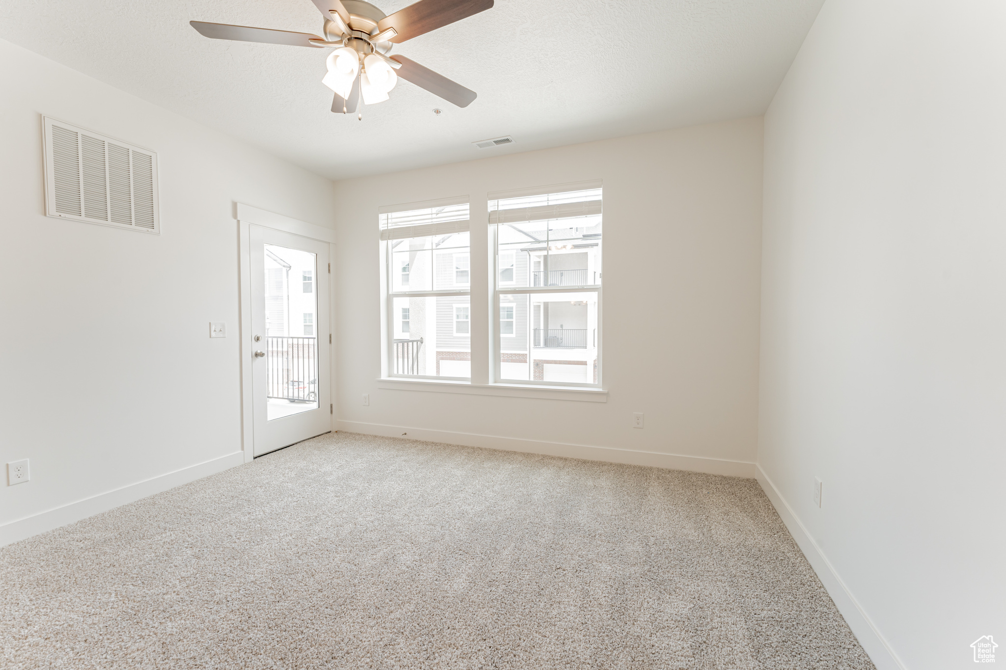 Spare room with ceiling fan and light carpet