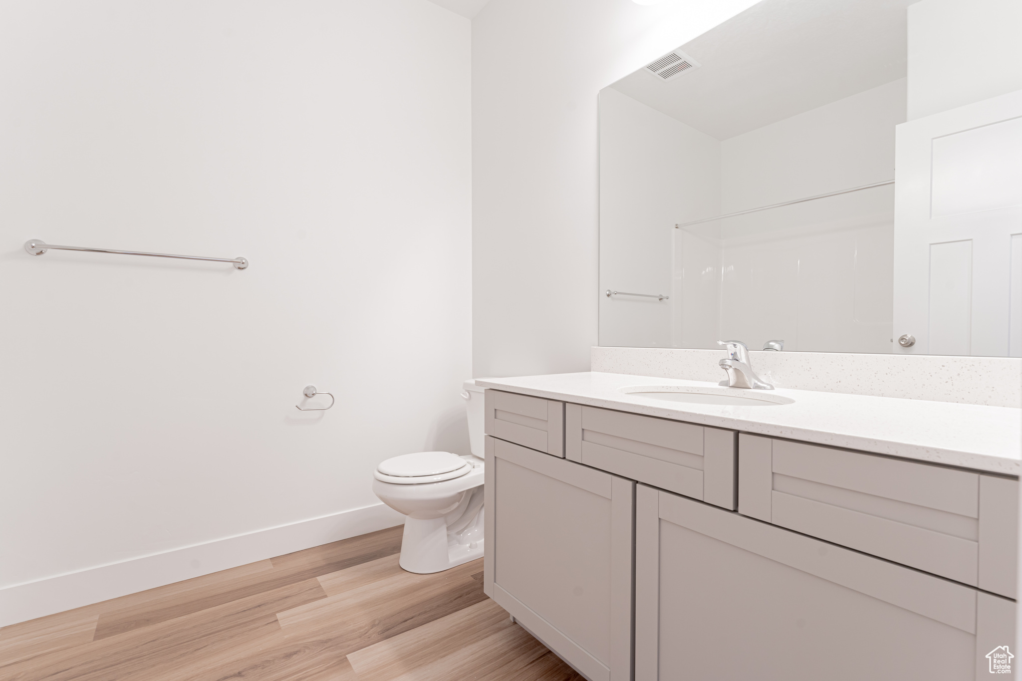 Bathroom with vanity, toilet, and wood-type flooring