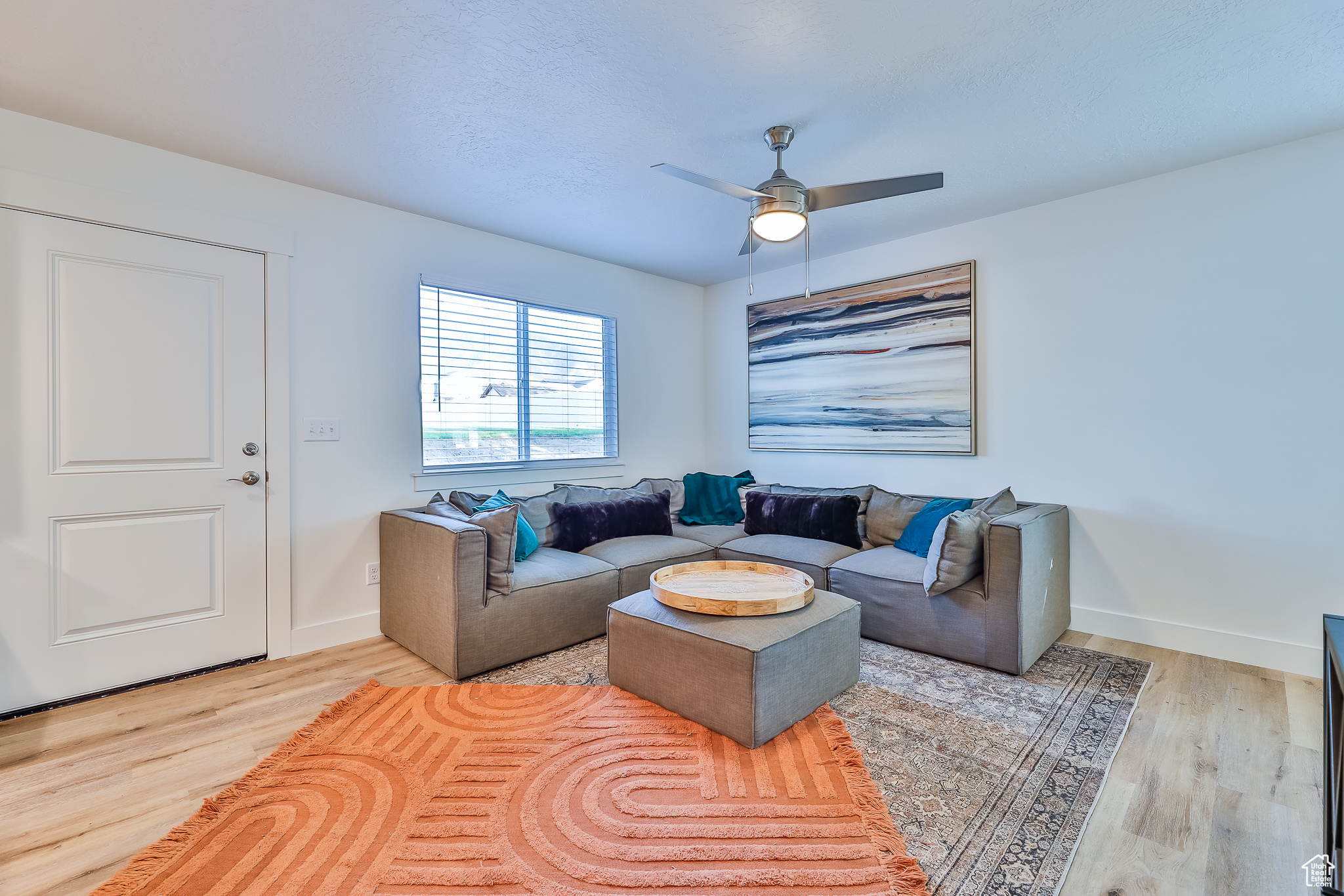 Living room with light hardwood / wood-style flooring and ceiling fan