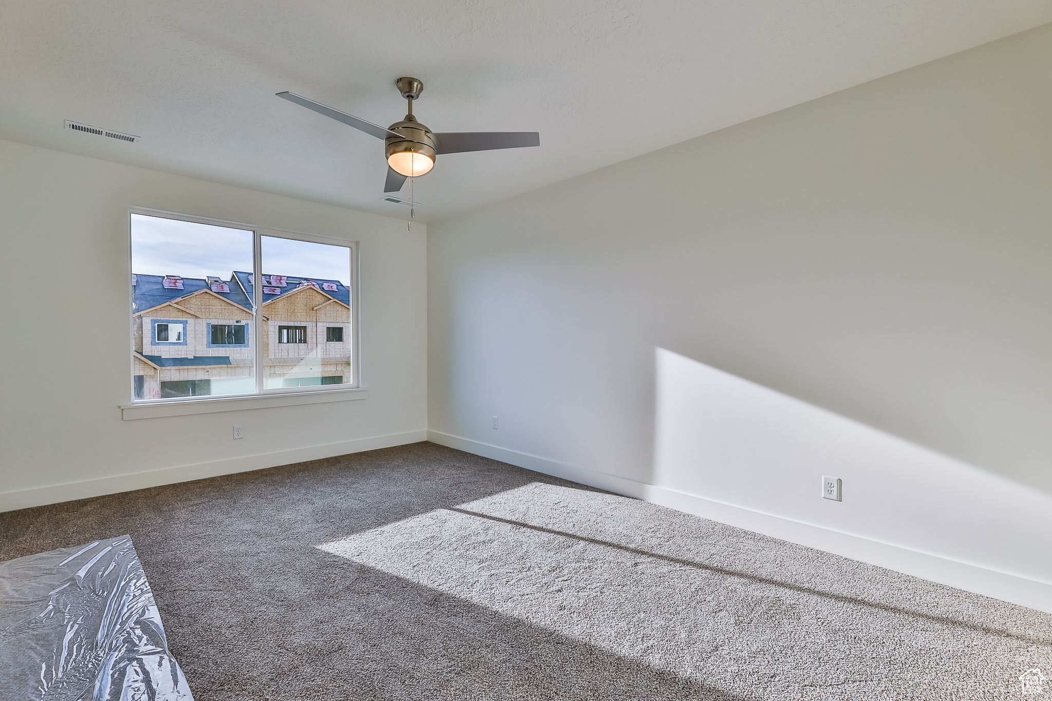 Carpeted empty room with ceiling fan