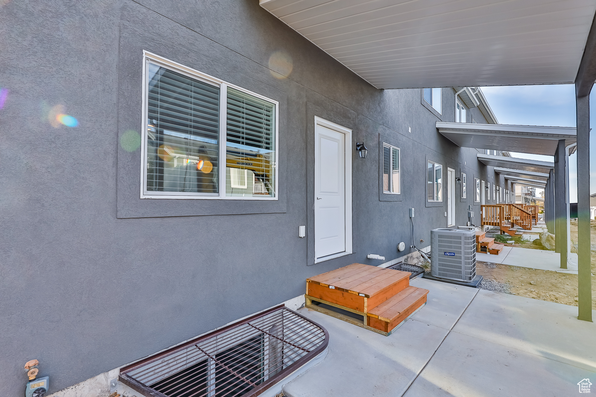 Doorway to property with central AC unit and a patio